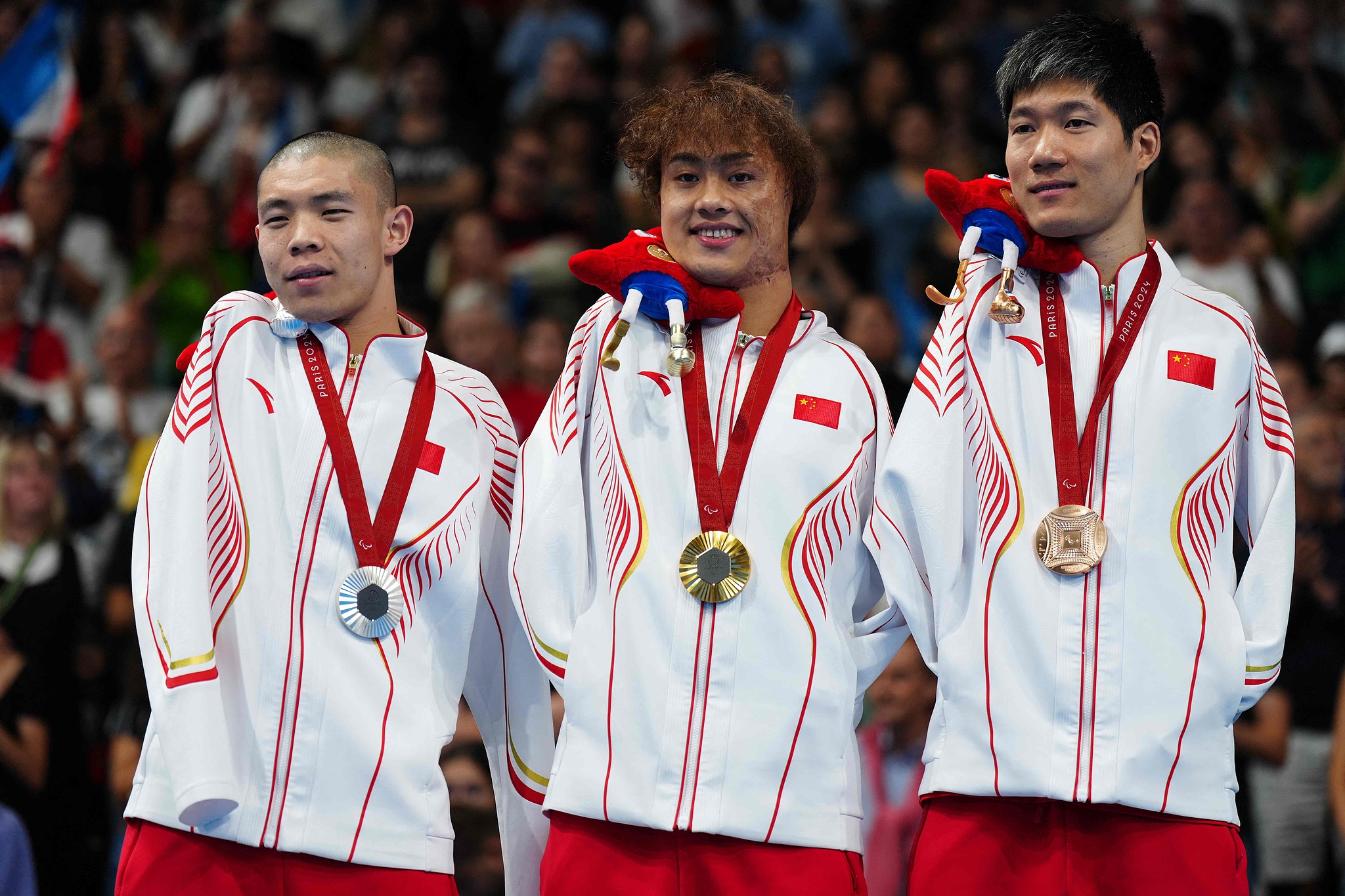 L-R: Silver medallist Guo Jincheng, gold medallist Yuan Weiyi and bronze medallist Wang Lichao of China pose for a photo after competing in the men's 50-meter backstroke swimming S5 final at the 2024 Summer Paralympic Games in Paris, France, September 3, 2024. /CFP