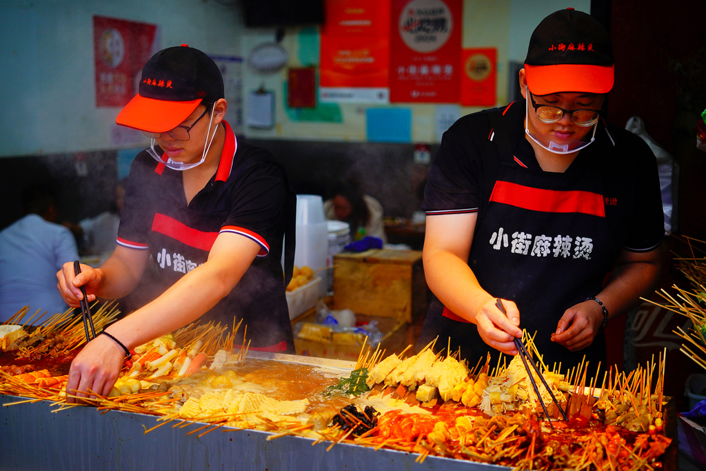 Workers line up skewered ingredients at a malatang stall in Beijing on September 4, 2024. /CFP