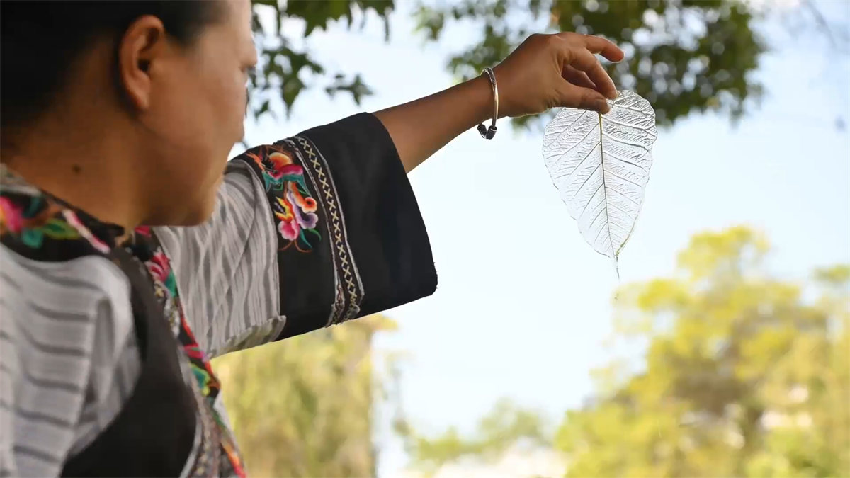 Yang Li shows a completed piece of leaf vein at a workshop in Tongren City, Guizhou Province. /Photo provided to CGTN