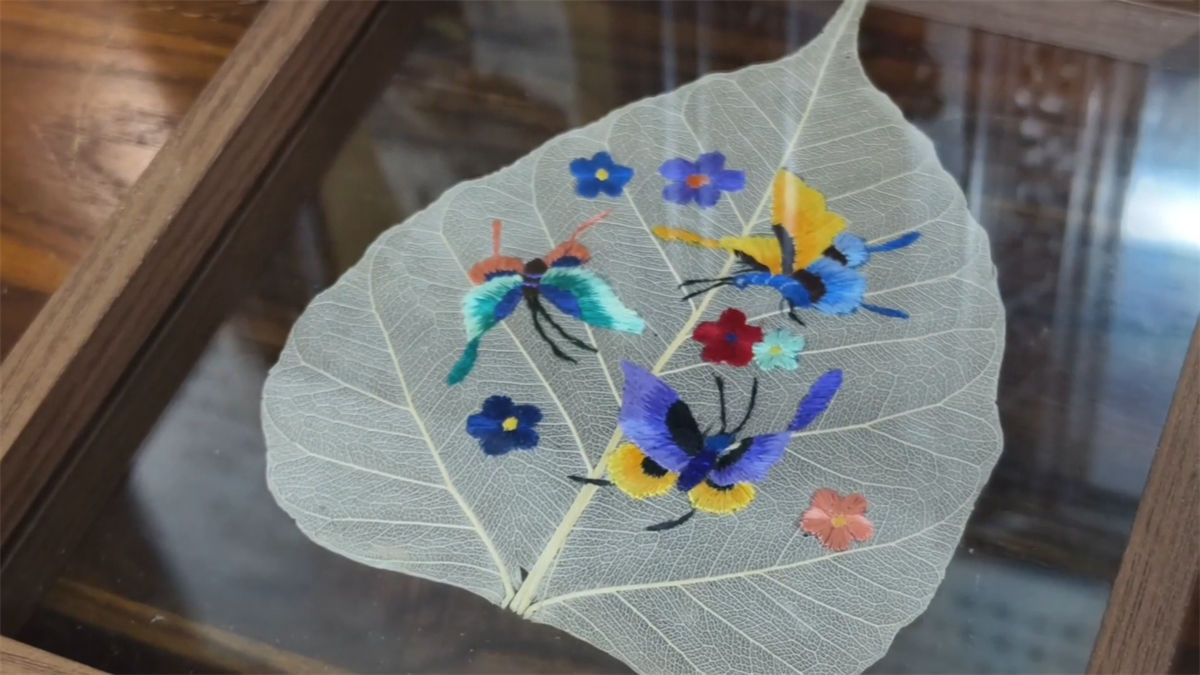 A piece of leaf-vein embroidery work with patterns of vivid butterflies and flowers is seen at a workshop in Tongren City, Guizhou Province. /Photo provided to CGTN