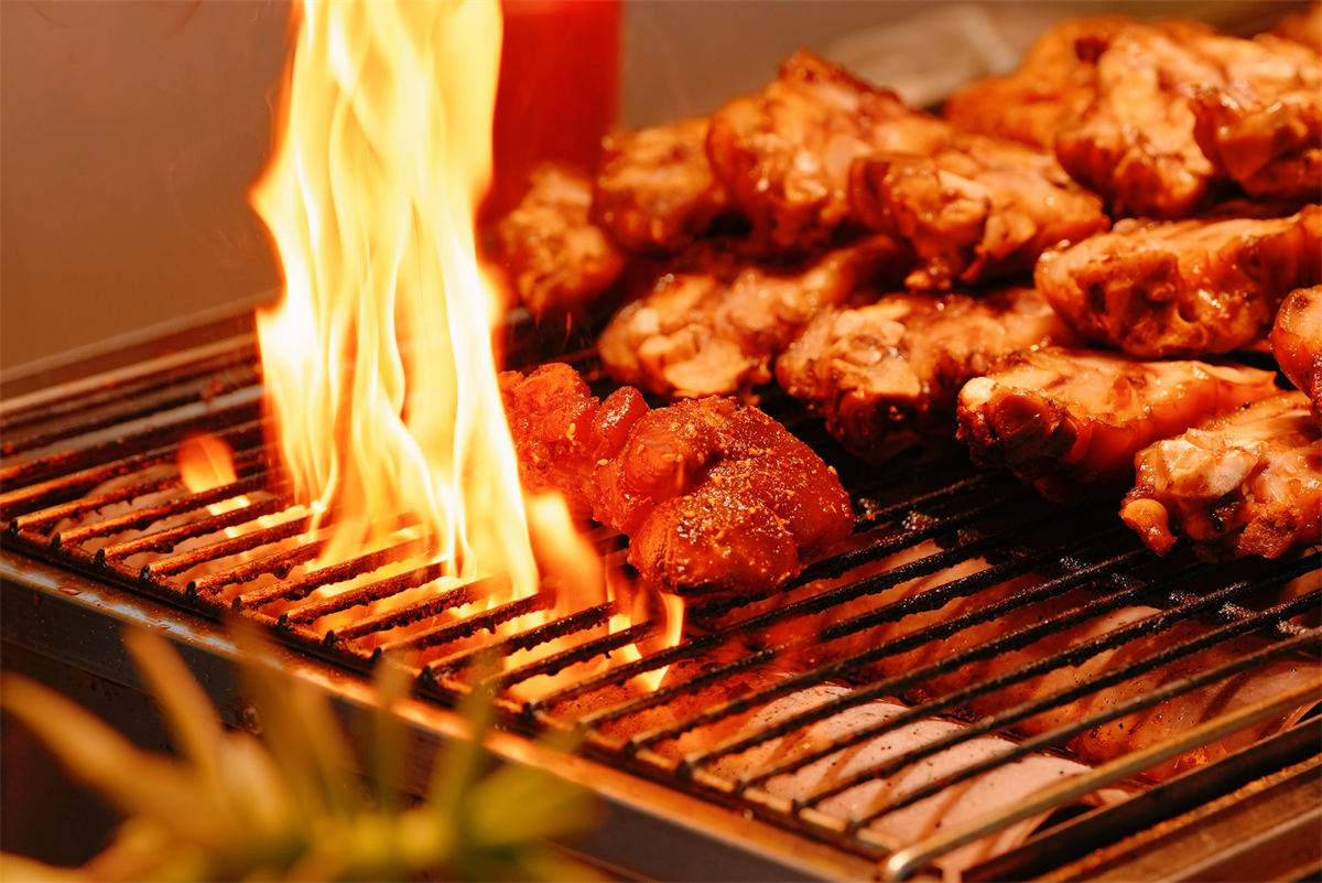 Almost cooked BBQ treats tempt passers-by with their mouthwatering aroma at the night market in Shenyang, Liaoning Province, August 19, 2024. /CGTN