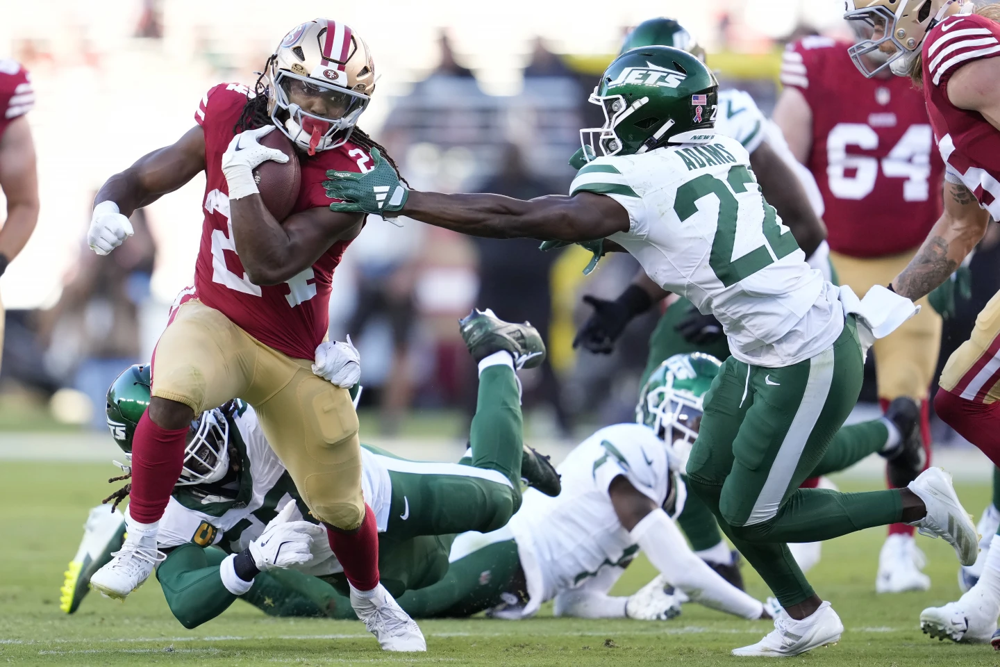 Pemain bertahan Jordan Mason (kiri) dari San Francisco 49ers membawa bola dalam pertandingan melawan New York Jets di Stadion Levi's di Santa Clara, California, 9 September 2024. /AP