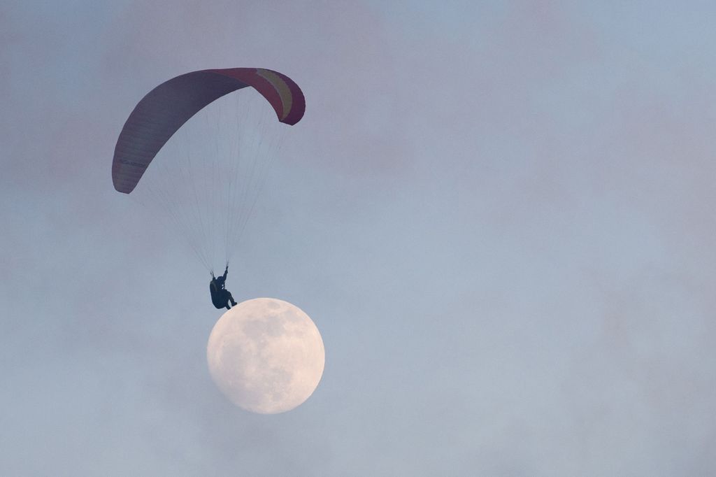 A paraglider and a full moon are captured in unison in this creative photograph. /CFP 