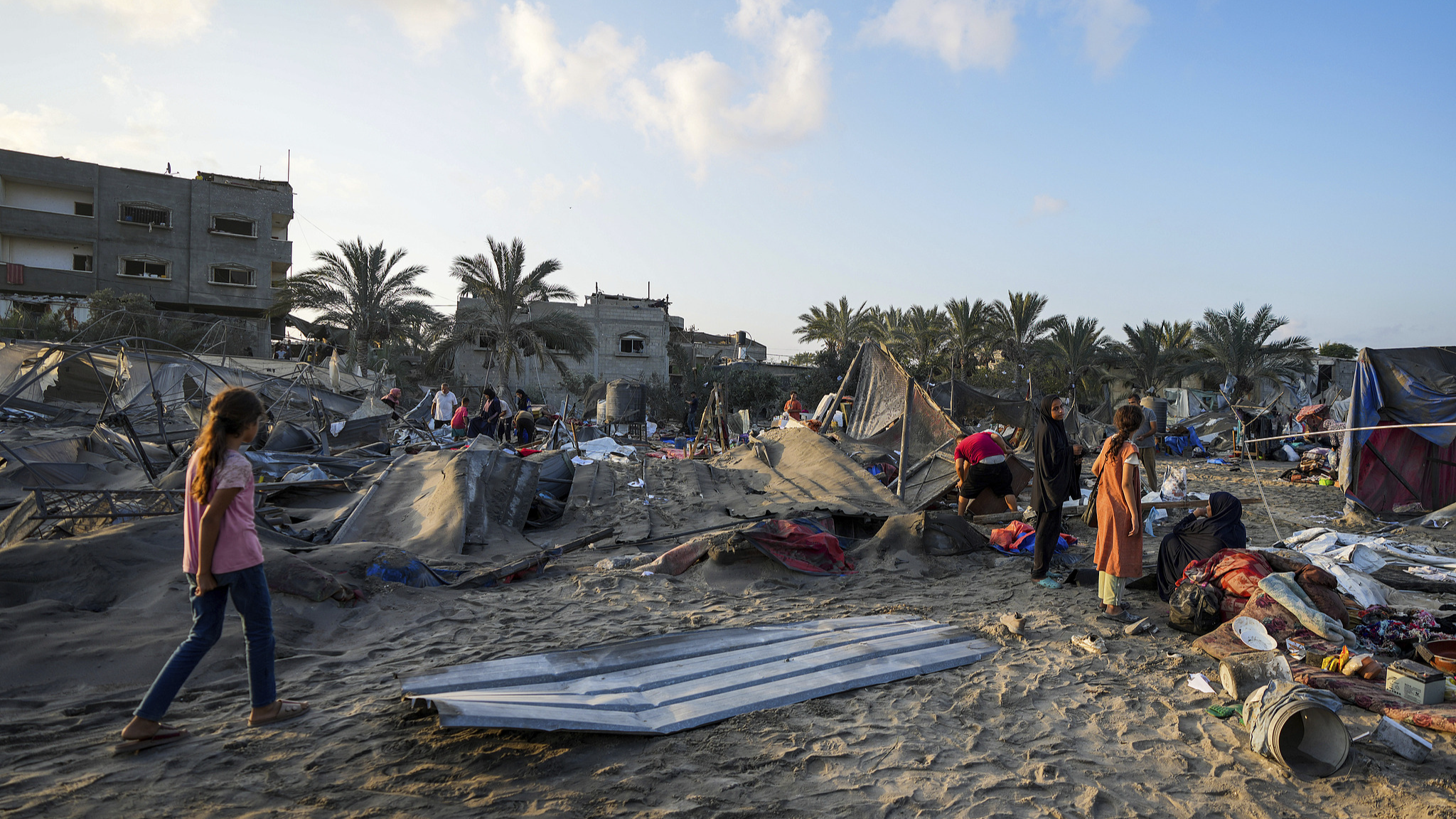 Palestinians look at the destruction after an Israeli airstrike on a crowded camp housing Palestinians displaced by the Israel-Hamas conflict, in Muwasi, west of Khan Younis, the Gaza Strip, September 10, 2024. /CFP