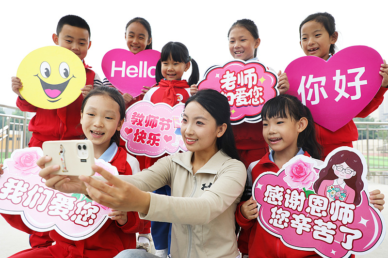 Seorang guru berswafoto dengan murid-muridnya untuk merayakan Hari Guru di Sekolah Dasar Huataidao di distrik Fengrun, Tangshan, Provinsi Hebei, Tiongkok Utara, 9 September 2024. /CFP