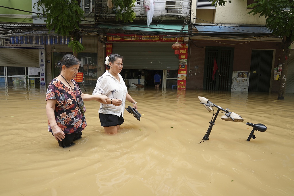 People wade in a flooded street in the aftermath of Typhoon Yagi in Hanoi, Vietnam, September 12, 2024. /CFP