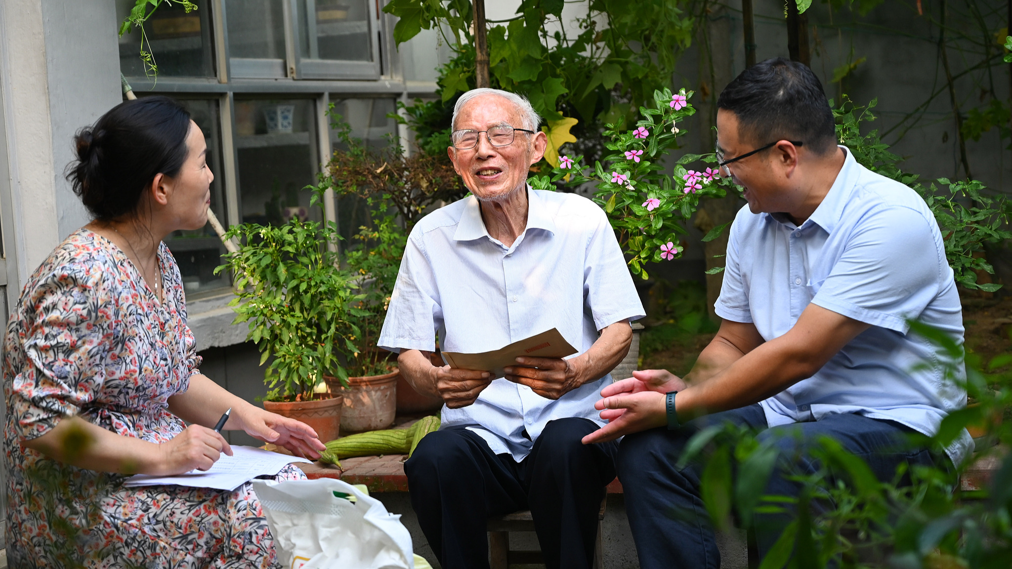 A retired man (C) chats with his guests at home, Xuzhou, east China's Jiangsu Province, September 7, 2022. /CFP