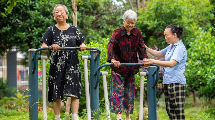 Senior residents exercise with the help of a staff member at a social welfare center in Hanshou County, Changde City, central China's Hunan Province, June 20, 2023. /Xinhua