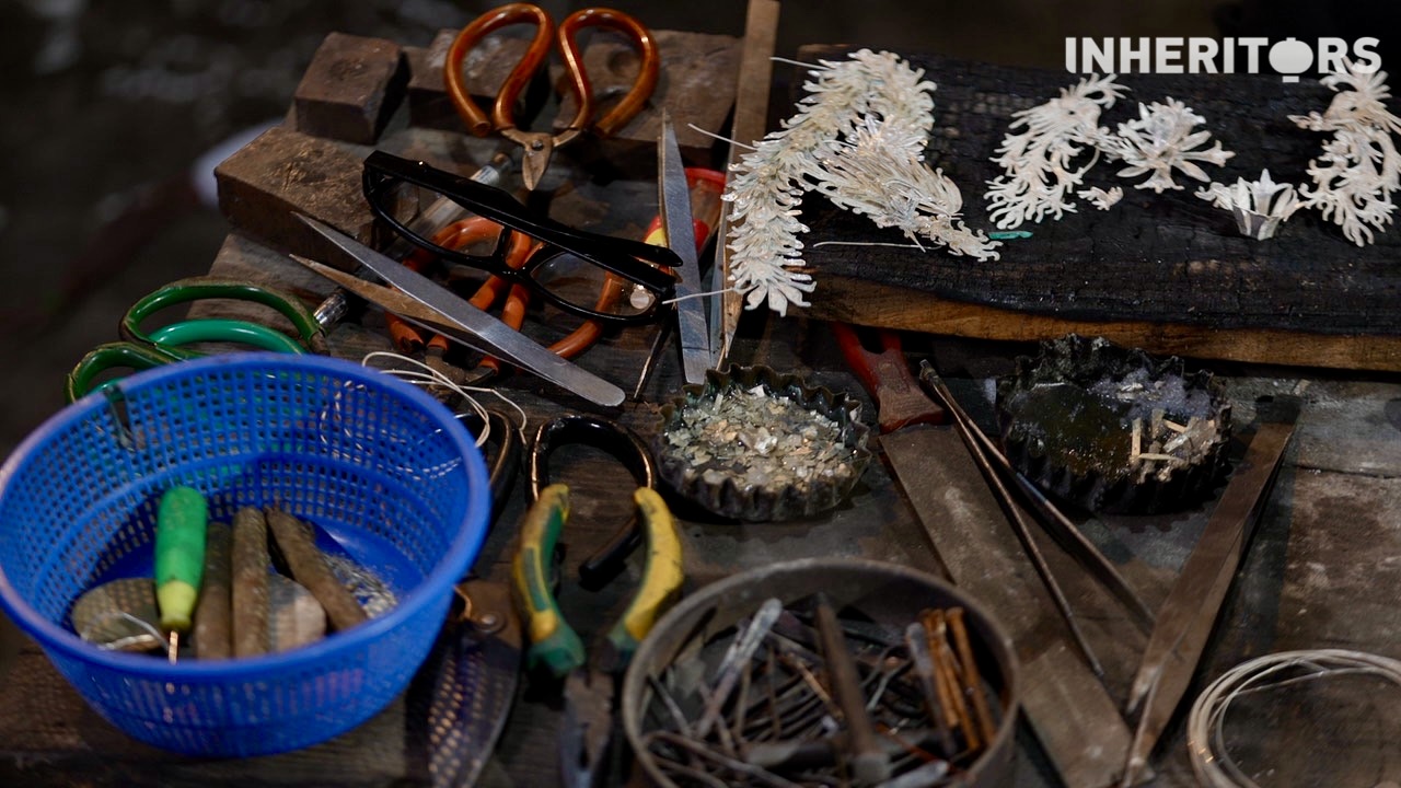 Some unfinished silver jewelry pieces and tools are seen in a workshop. /CGTN