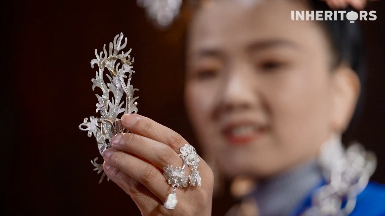 A female Miao silversmith makes silver jewelry pieces. /CGTN