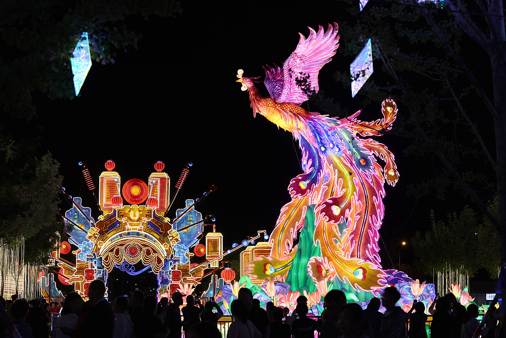 Visitors admire a phoenix and a Peking Opera costumed lantern sculpture at a lantern show in Beijing Garden Expo Park on September 14, 2024. /CFP