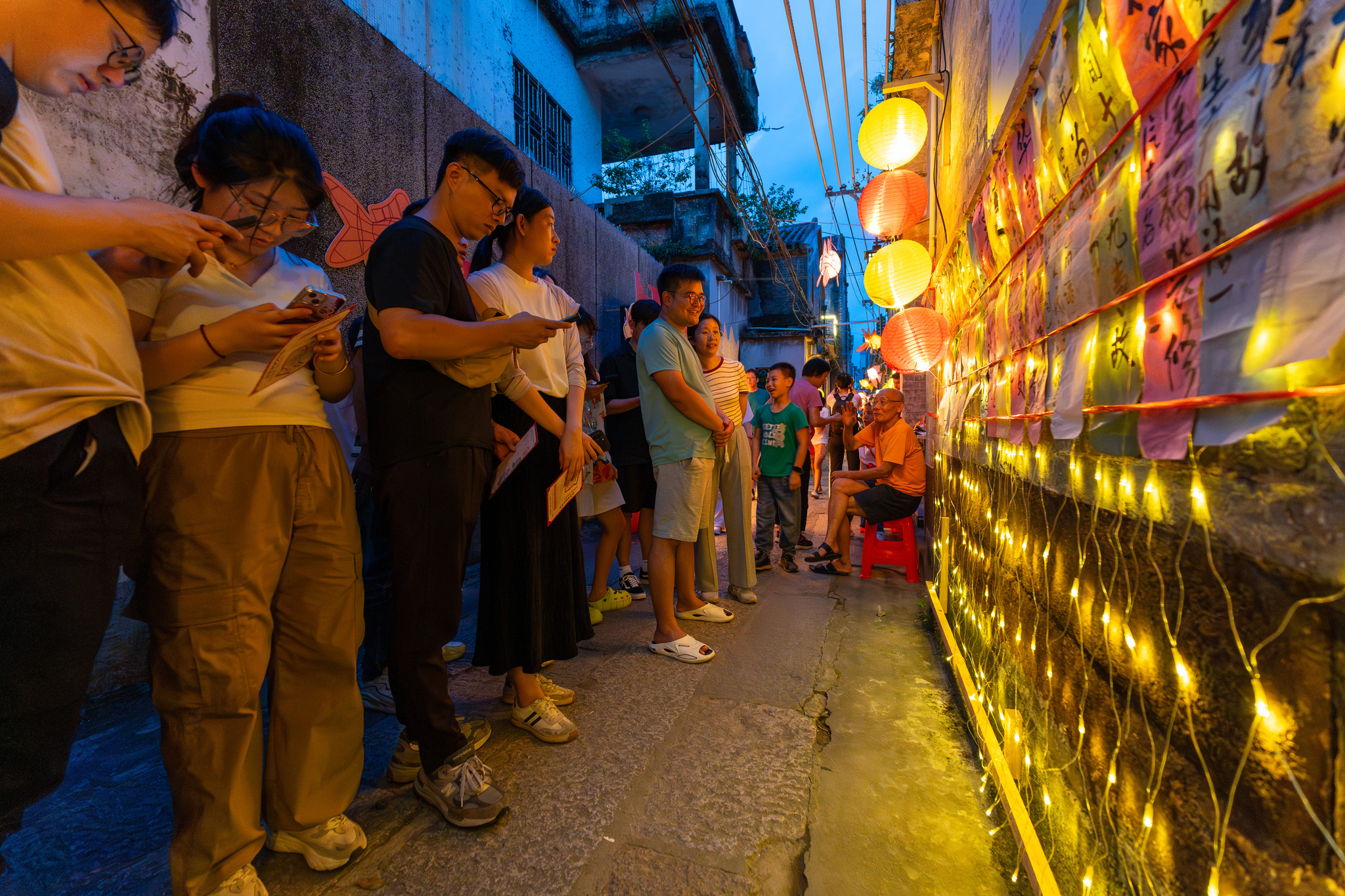 Visitors guess riddles pasted on walls at the fourth Daliang Fish Lantern Festival in Foshan, Guangdong Province on September 15, 2024. /CFP