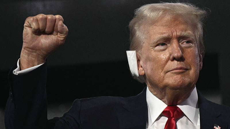 U.S. former President and 2024 Republican presidential candidate Donald Trump, a bandage on his ear after being wounded in an assassination attempt, raises a fist as he arrives during the first day of the 2024 Republican National Convention, Wisconsin, July 15, 2024. /CFP