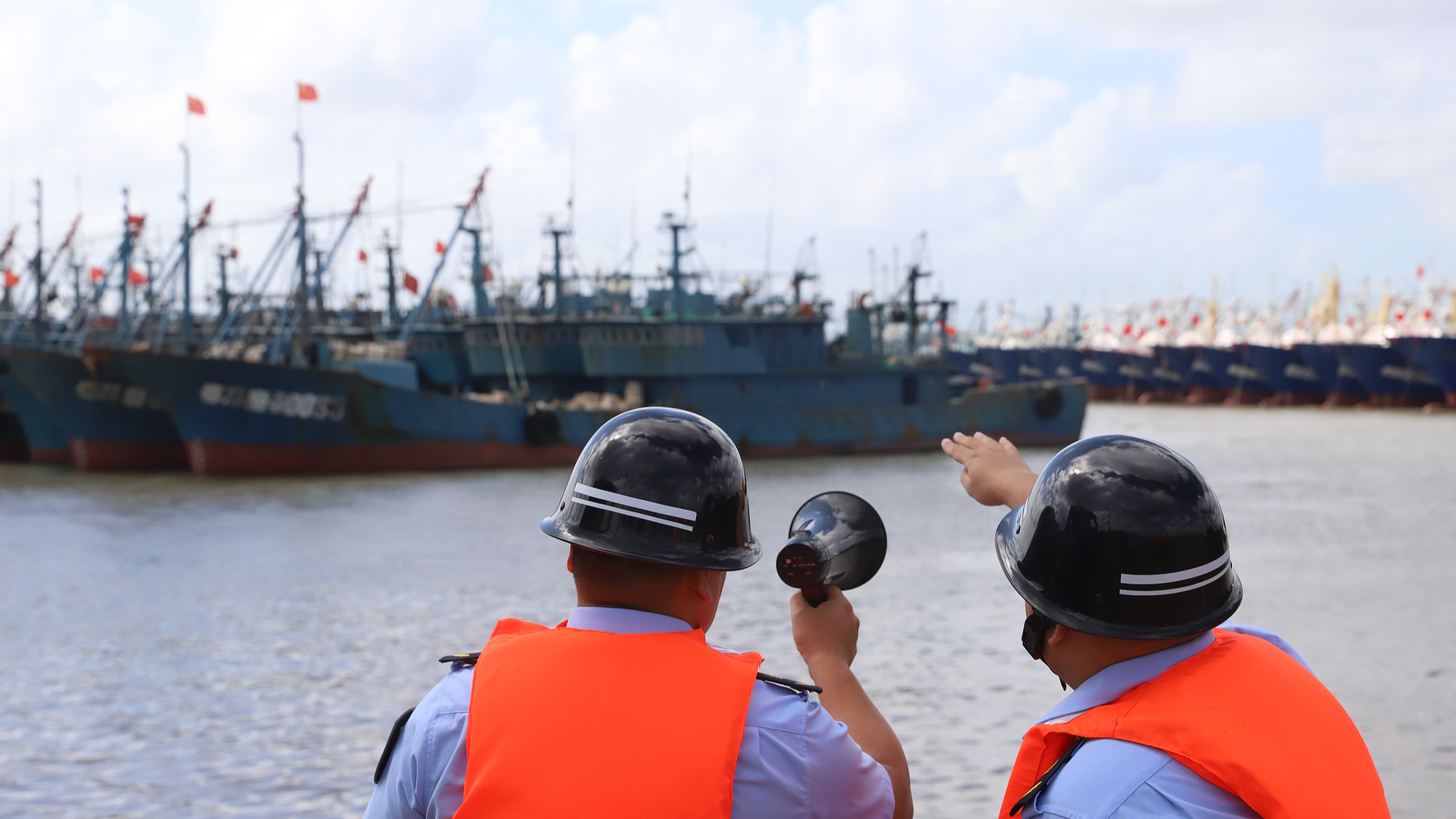 Petugas mengatur evakuasi personel yang bekerja di kapal penangkap ikan sebelum Topan Pulasan tiba di Kota Jinqing, Distrik Luqiao di Kota Taizhou, Provinsi Zhejiang, 18 September 2024. /CFP