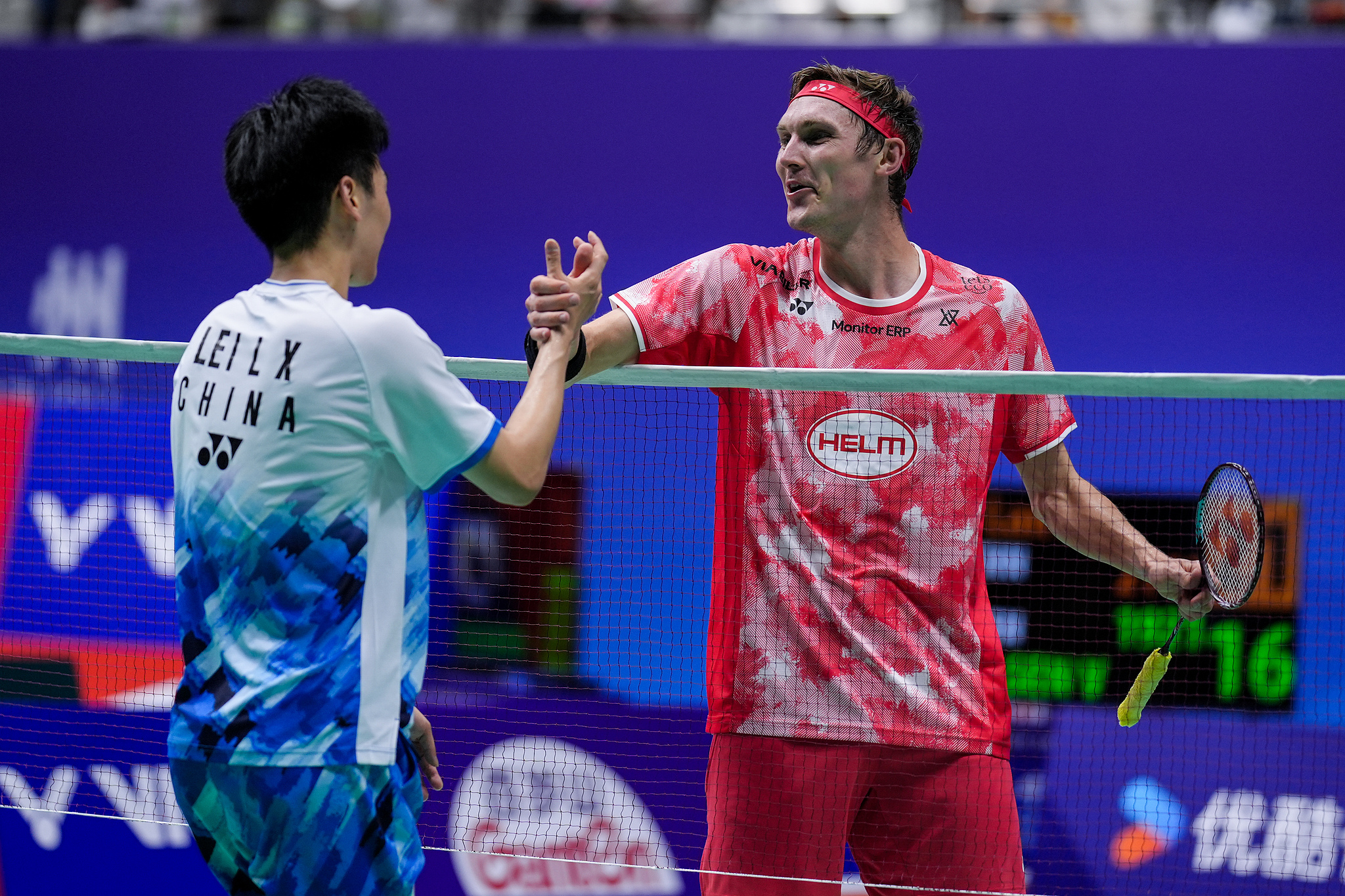 Lei Lanxi (L) of China shakes hands with Viktor Axelsen of Denmark at the net after their men's singles first round match at the BWF China Open in Changzhou, China, September 18, 2024. /CFP