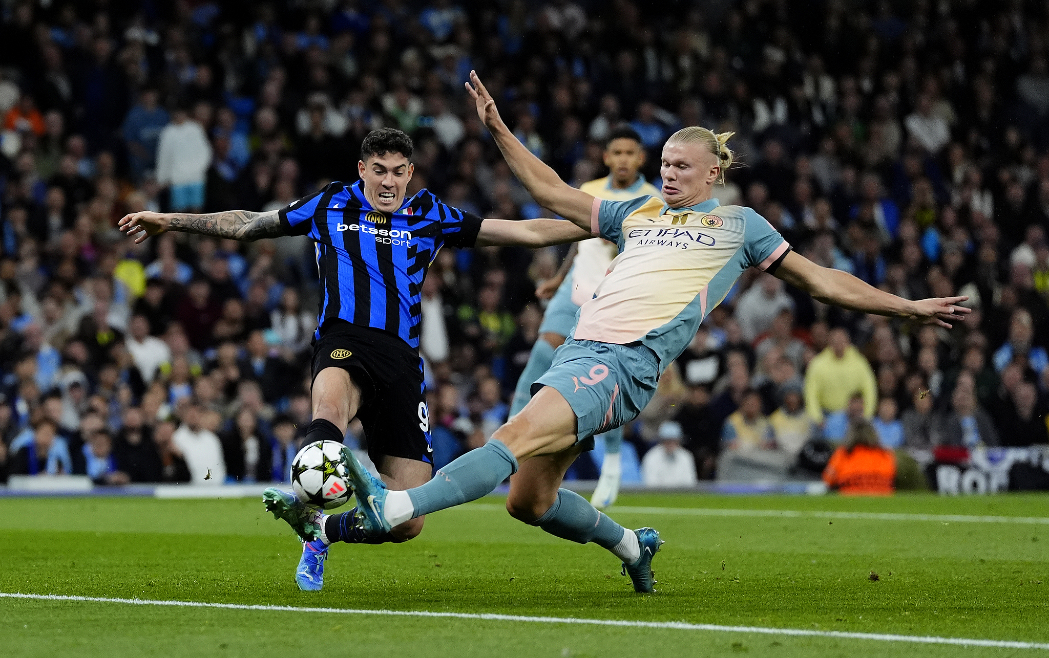 Manchester City's Erling Haaland (R) and Inter Milan's Alessandro Bastoni battle for the ball in a UEFA Champions League match at the Etihad Stadium in Manchester, England, September 18, 2024. /CFP