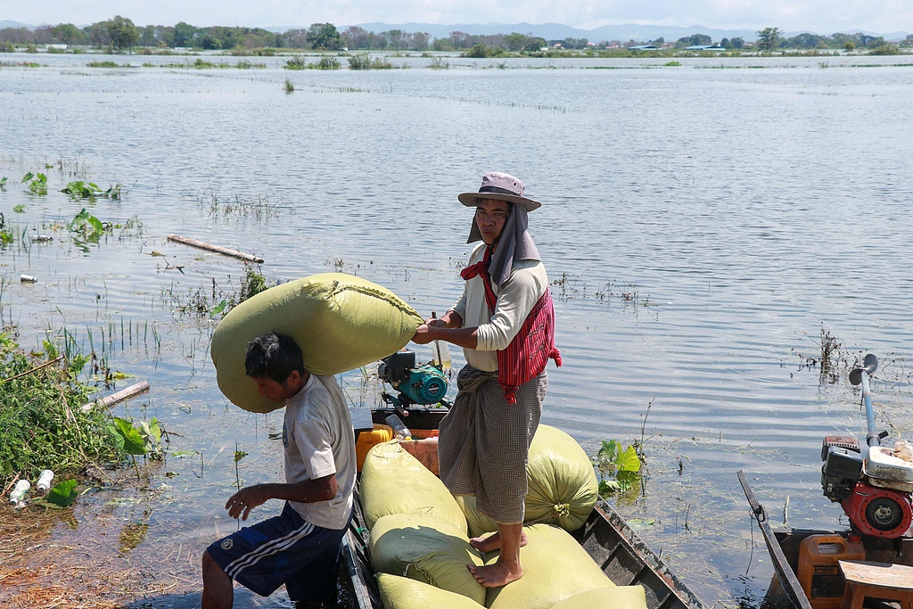 Farmers carry bags of rice as they evacuate their homes near Phayarphyu village in Loikaw township in Myanmar's Karen state following heavy rains in the aftermath of Typhoon Yagi. September 16, 2024. /CFP