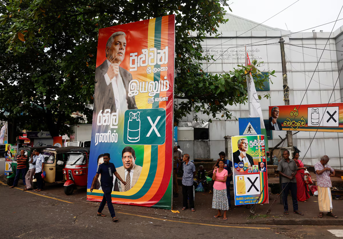 People walk near posters of Sri Lankan President Ranil Wickremesinghe before his final rally at a residential area for the upcoming presidential election, scheduled for September 21, in Colombo, Sri Lanka September 18, 2024. /Reuters

