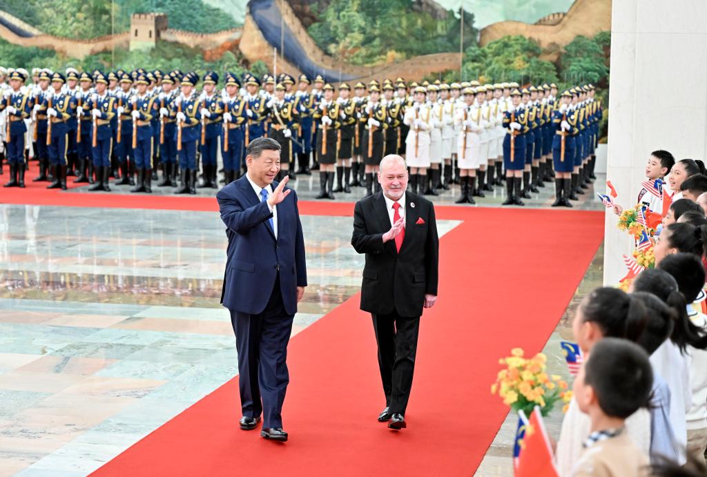 Chinese President Xi Jinping and Malaysia's King Sultan Ibrahim Sultan Iskandar, who is on a state visit to China, wave to children at a welcoming ceremony in the Northern Hall of the Great Hall of the People prior to their talks in Beijing, China, September 20, 2024. /Xinhua