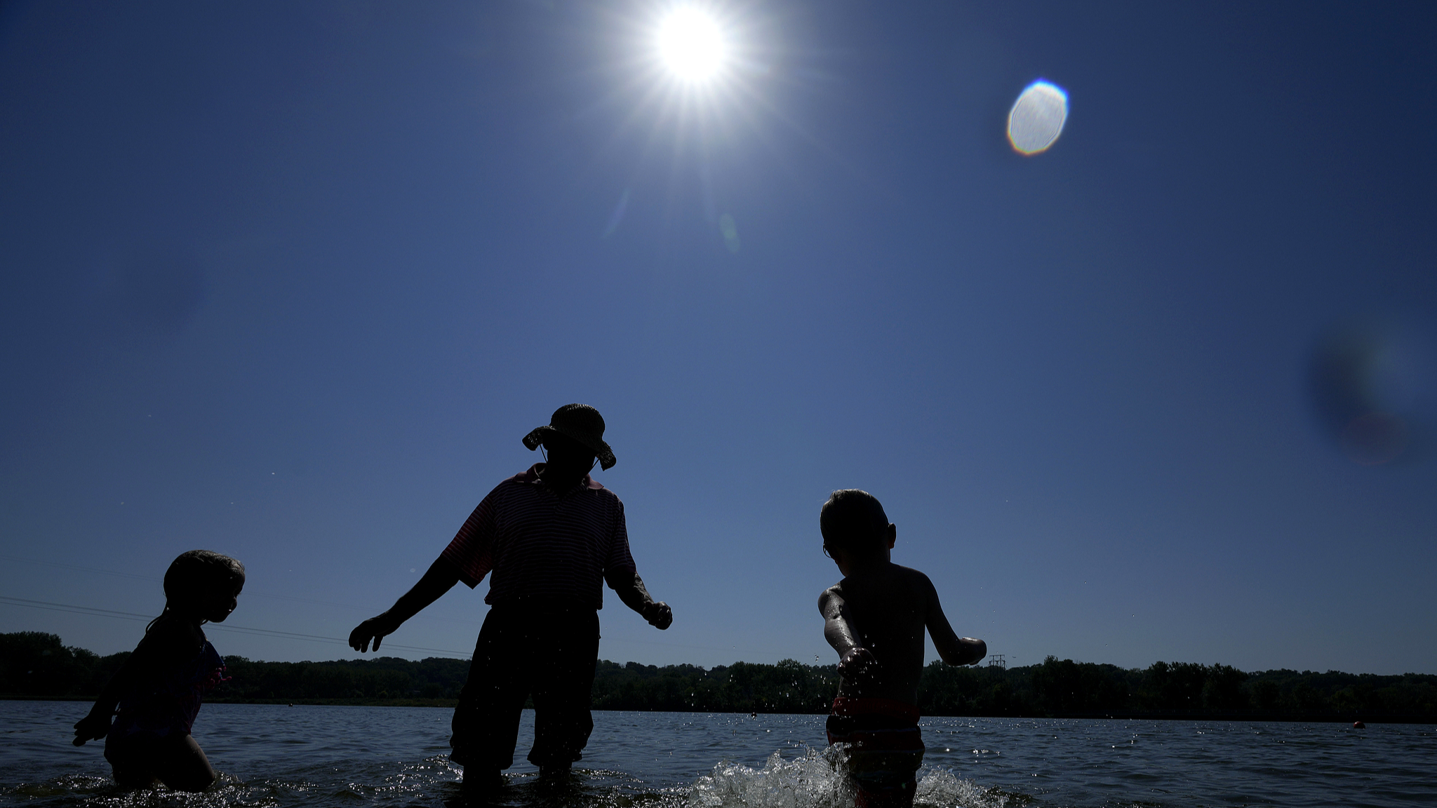 People stand in the water for cooling at Gray's Lake Park, Des Moines, Iowa, August 26, 2024. /CFP