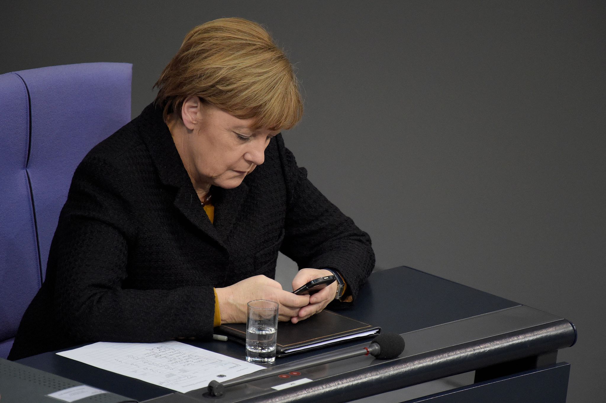 Kanselir Jerman Angela Merkel menggunakan telepon genggamnya selama sesi Bundestag di Berlin, 16 Desember 2015. /CFP