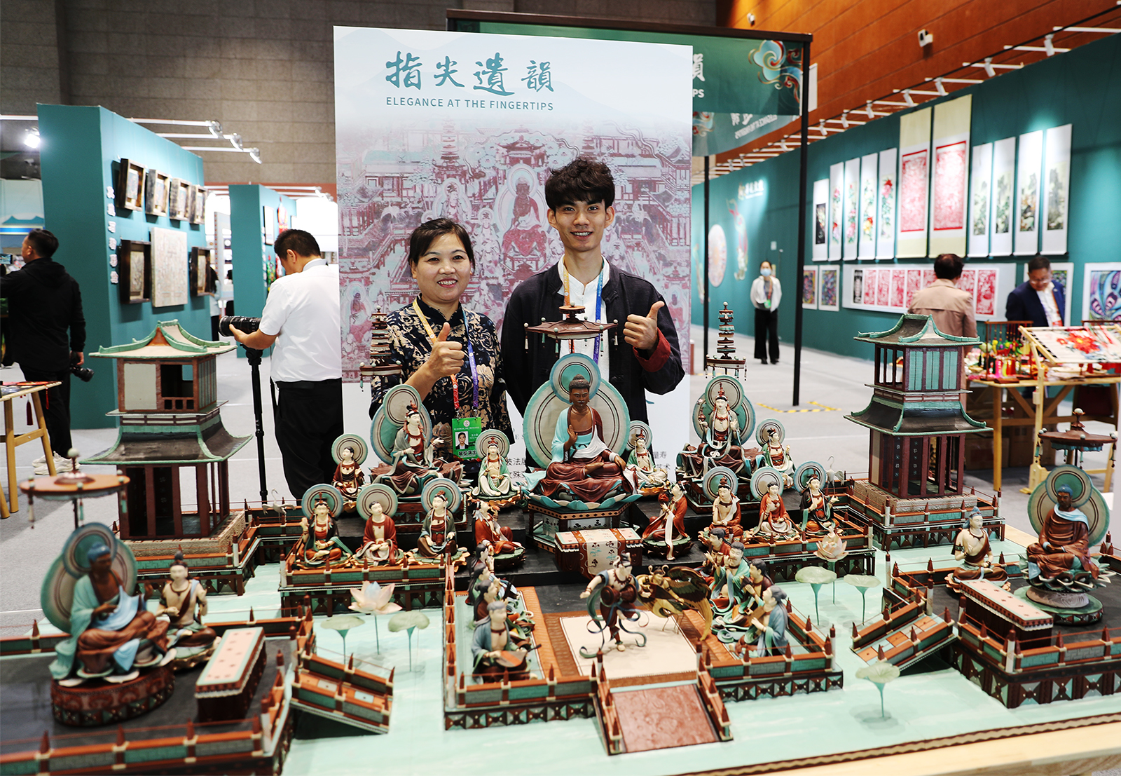 Yang Kai dan ibunya berpose untuk foto di balik karya seni pahat adonan mereka di Pameran Budaya Internasional Jalur Sutra (Dunhuang) di Dunhuang, Provinsi Gansu pada 21 September 2024. /CGTN