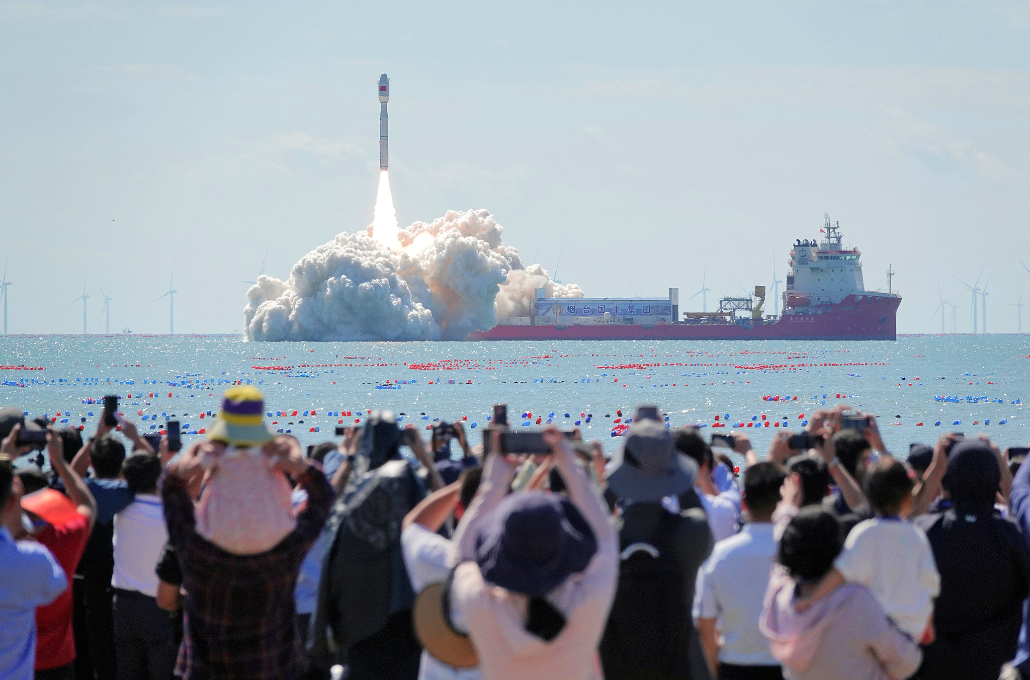 Spectators watch the launch of the Smart Dragon-3 carrier rocket on the seashore in Haiyang City, Shandong Province, China, September 24, 2024. /CFP