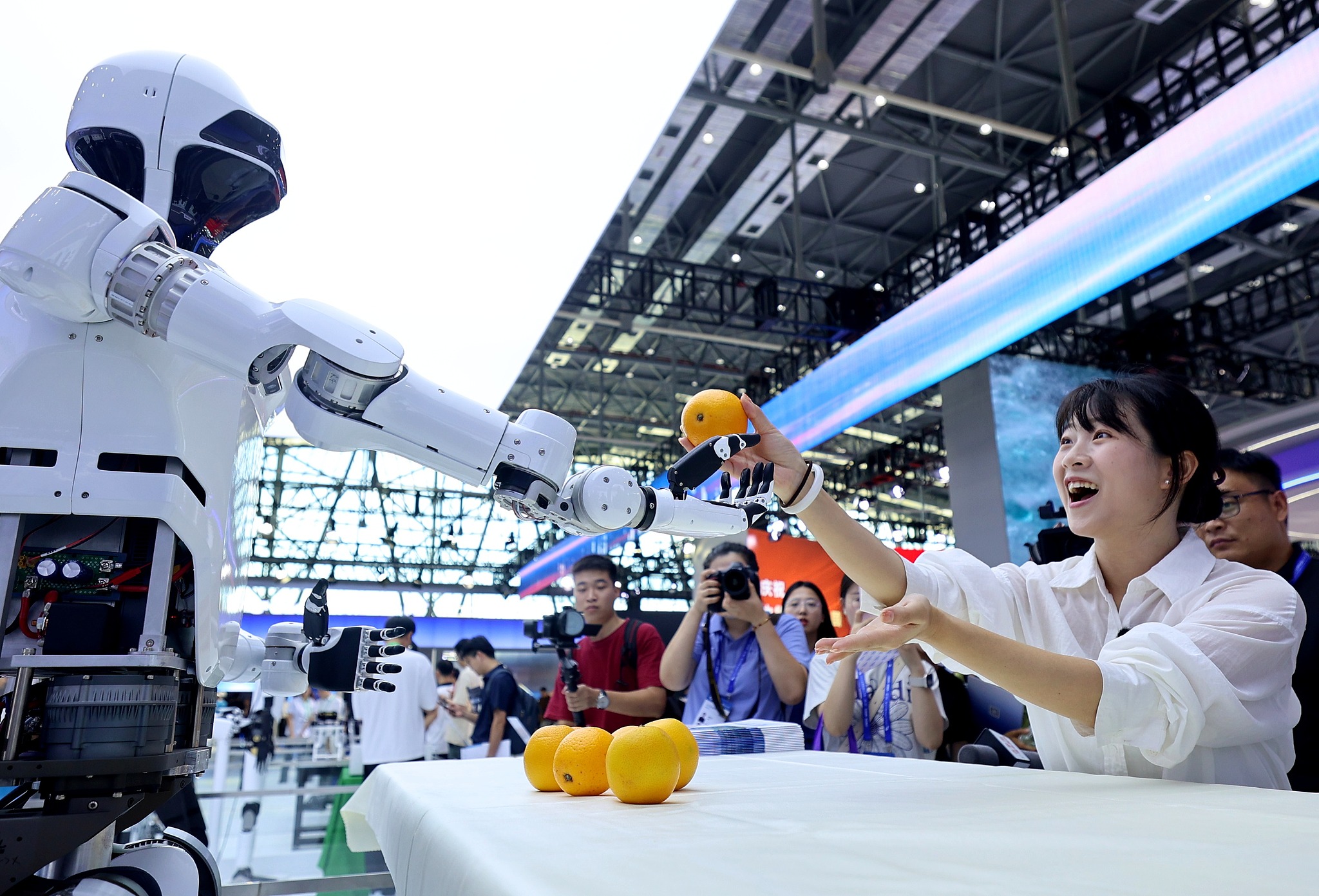 A Qijiang-2 humanoid robot hands an orange to a visitor at the 2024 World Manufacturing Convention in Hefei City, east China's Anhui Province, September 20, 2024. /CFP