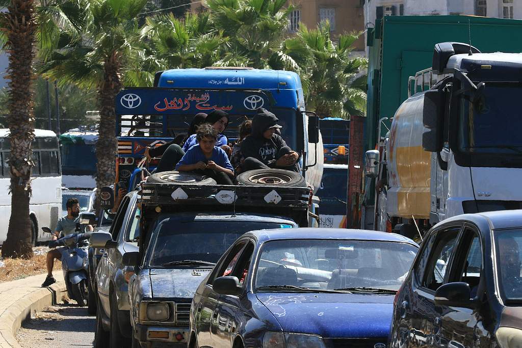 A Syrian family sit with their belongings in the back of a truck as they wait in a traffic jam in the southern Lebanese city of Sidon, September 23, 2024. /CFP