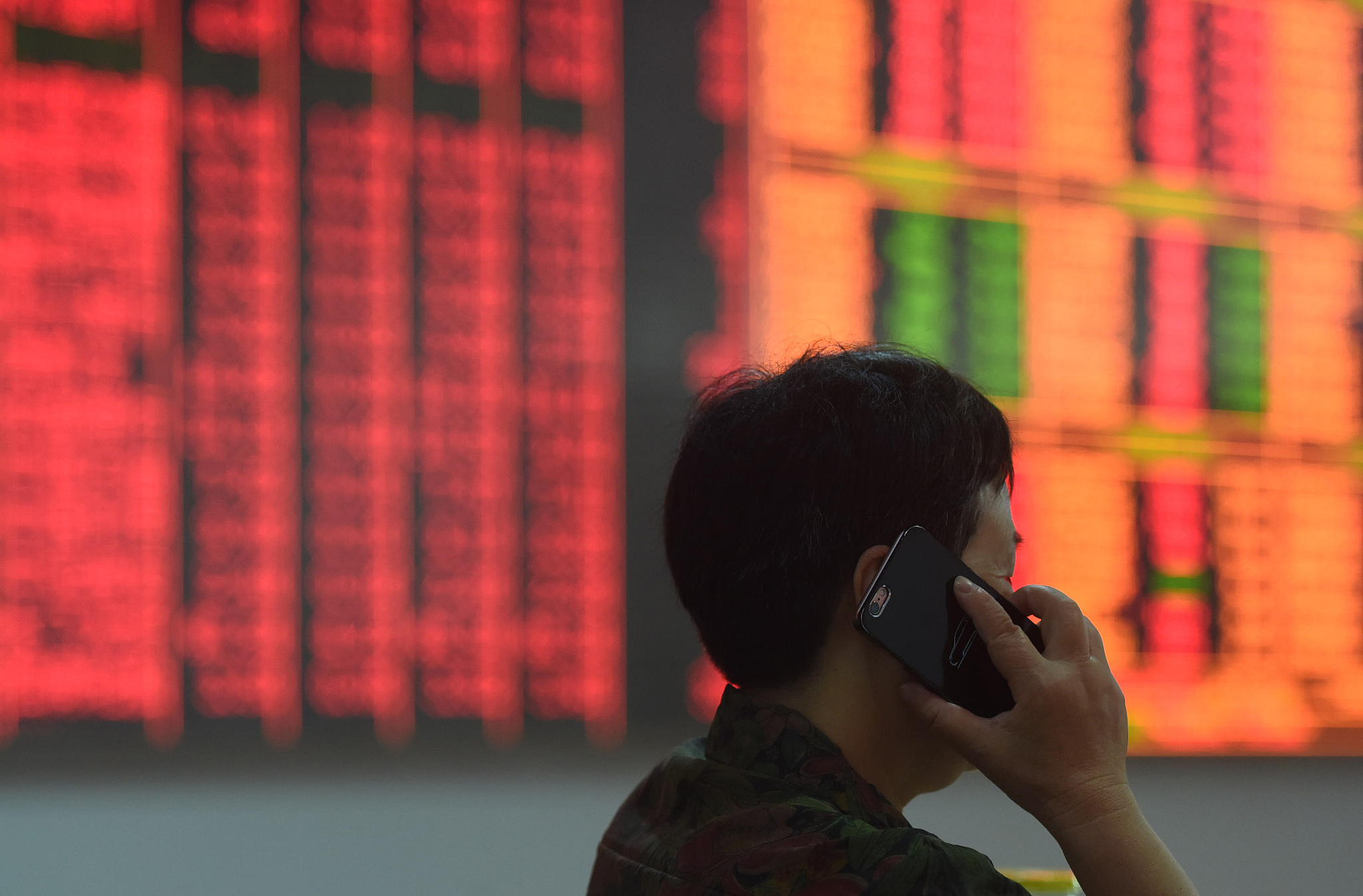 An investor walks past an electronic display showing prices of shares at a brokerage house in Hangzhou, east China's Zhejiang Province, September 24, 2024. /CFP 