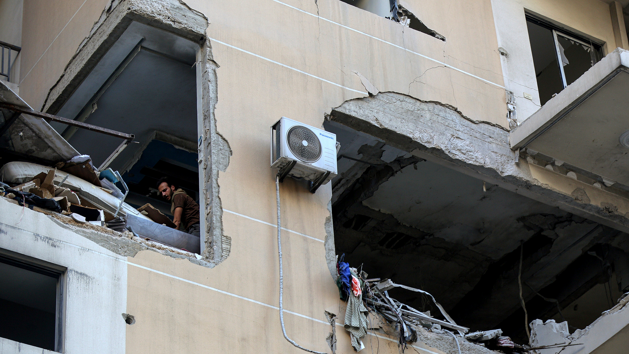 A Lebanese civil defense worker search in rubble and debris of an apartment in a building targeted by an Israeli air strike in Beirut's southern suburb, Beirut, Lebanon, September 26, 2024. /CFP