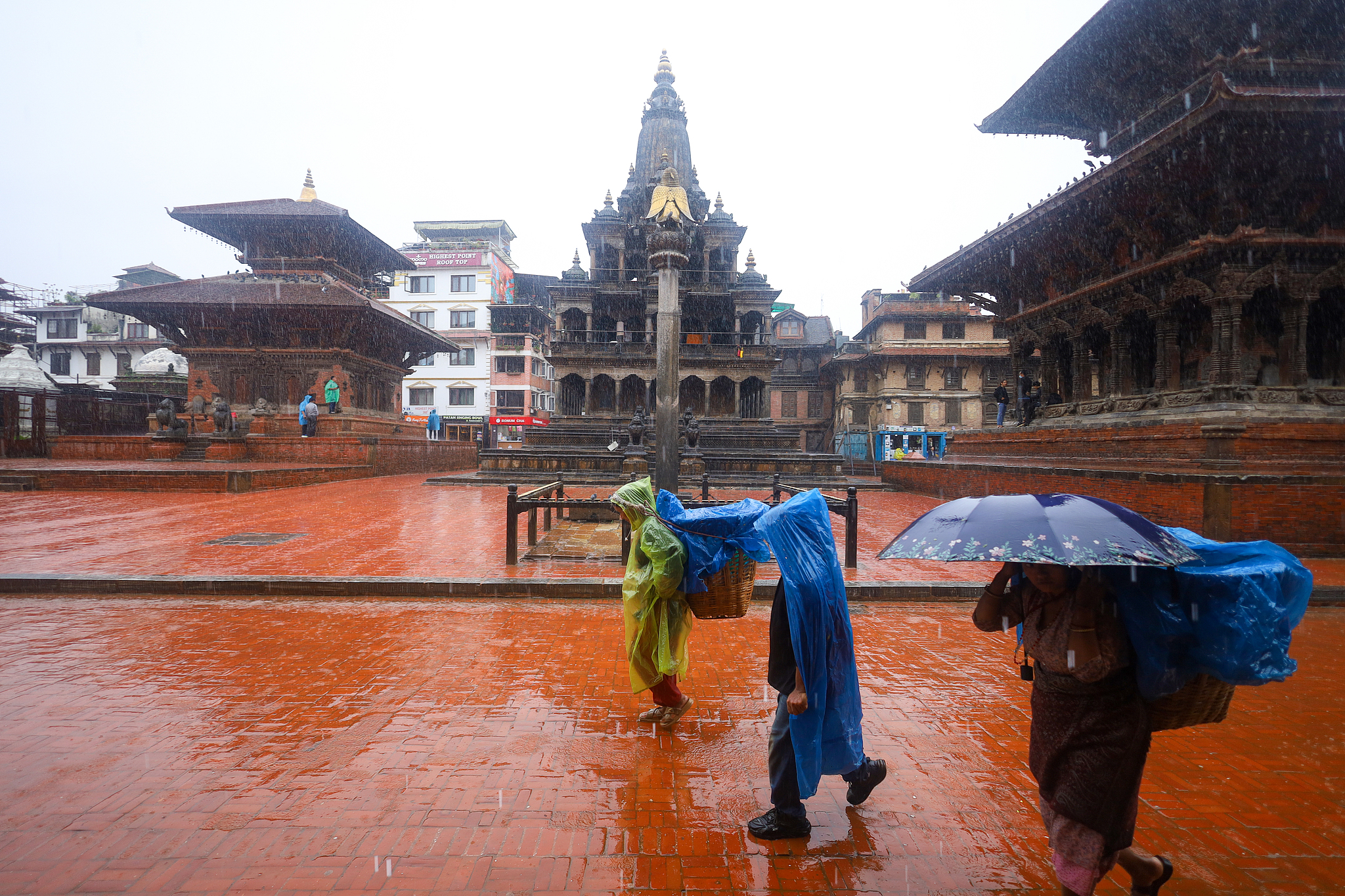 People with umbrellas walk around Patan Durbar Square, a UNESCO World Heritage Site in Lalitpur, Nepal, after incessant rainfall following a red alert issued by Nepal's weather department on September 27, 2024. /CFP