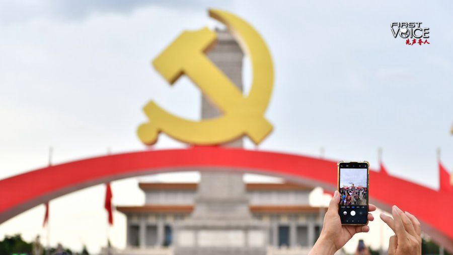 A man takes photos of the decoration set up for the ceremony marking the 100th anniversary of the founding of the Communist Party of China at Tian'anmen Square in Beijing, July 3, 2021. /Xinhua