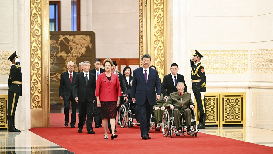 Chinese President Xi Jinping, also general secretary of the Communist Party of China Central Committee and chairman of the Central Military Commission, walks with some of the recipients of the national medals and honorary titles at a ceremony in the Great Hall of the People in Beijing, China, September 29, 2024. /Xinhua