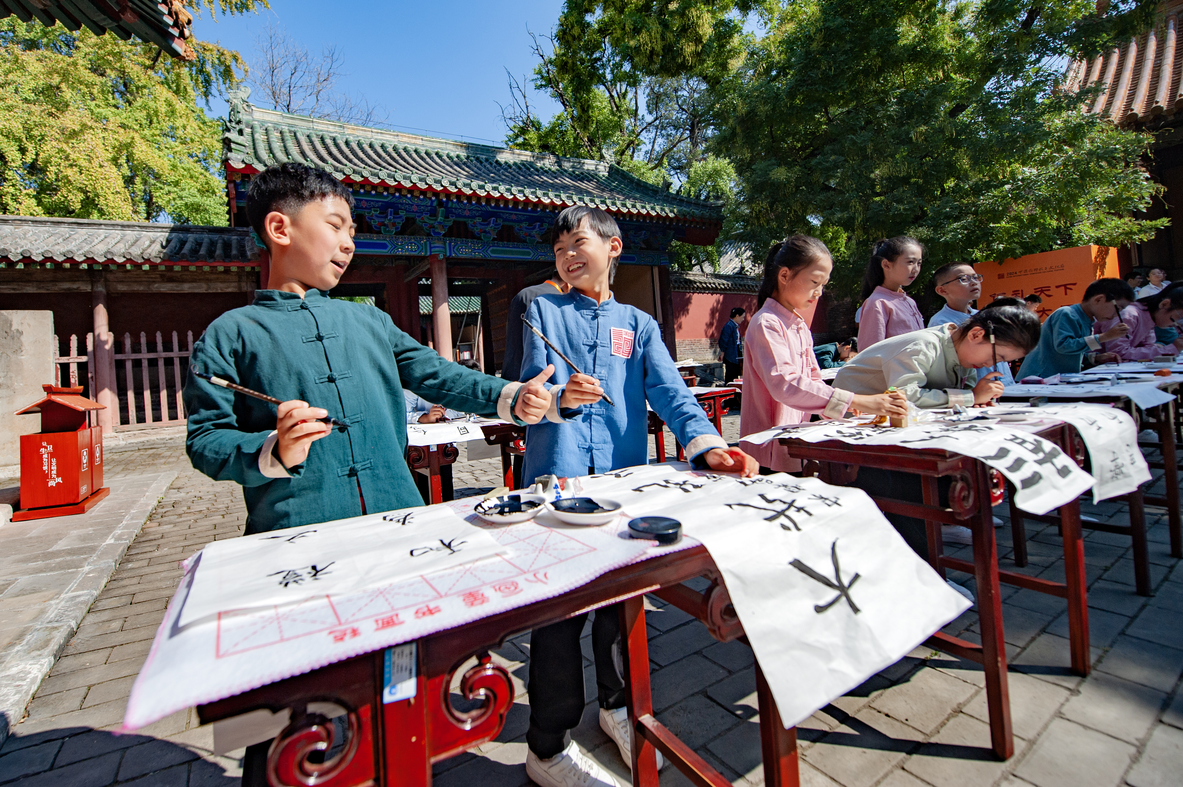 Children write calligraphy at the 2024 Grand Ceremony of Worship of Confucius in Qufu, Shandong Province on September 28, 2024. /Photo provided to CGTN