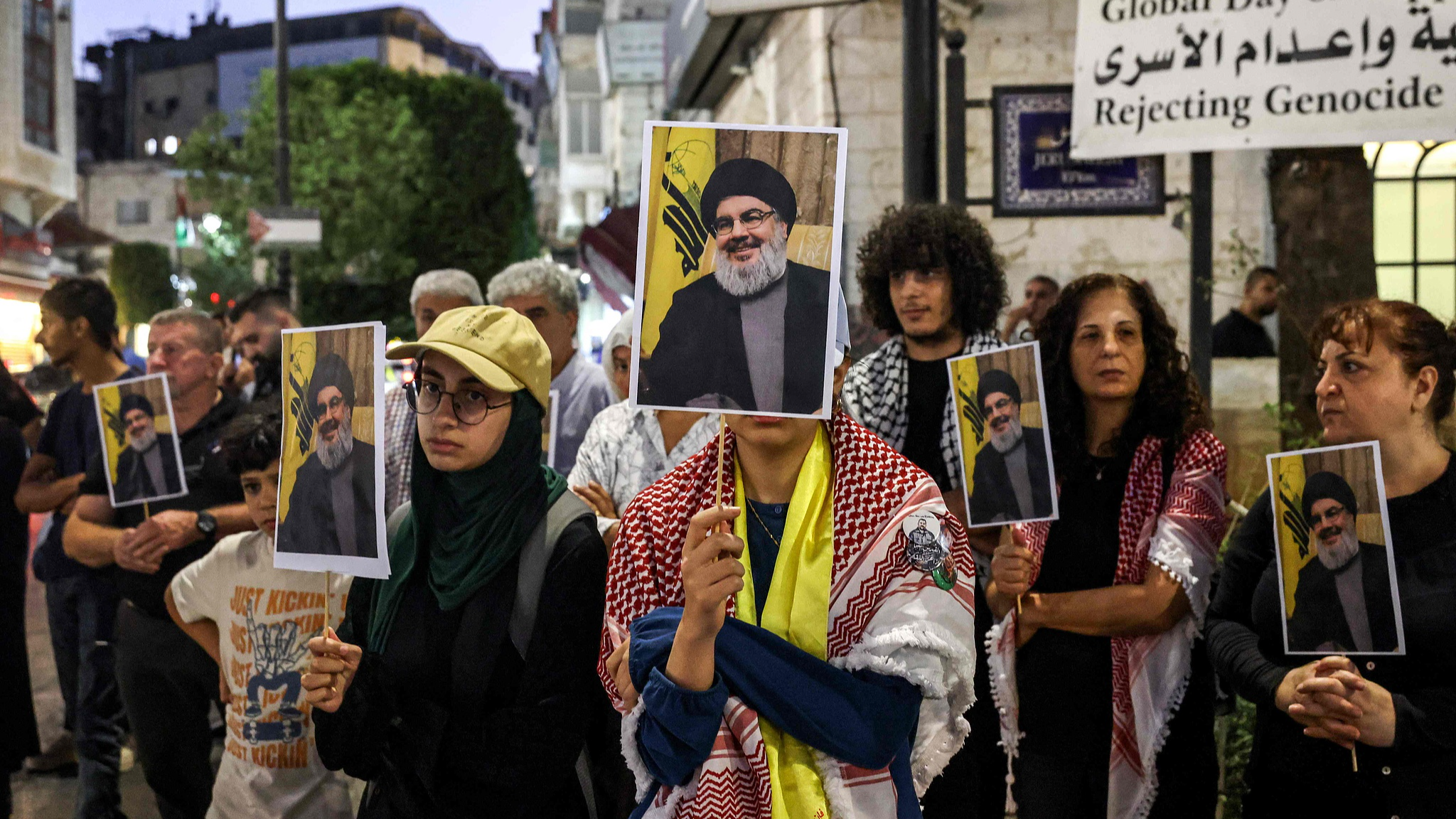 Demonstrators stand with signs showing the face of the late leader of Hezbollah, Hassan Nasrallah, during a protest vigil in the city of Ramallah in the occupied West Bank, September 28, 2024. /CFP