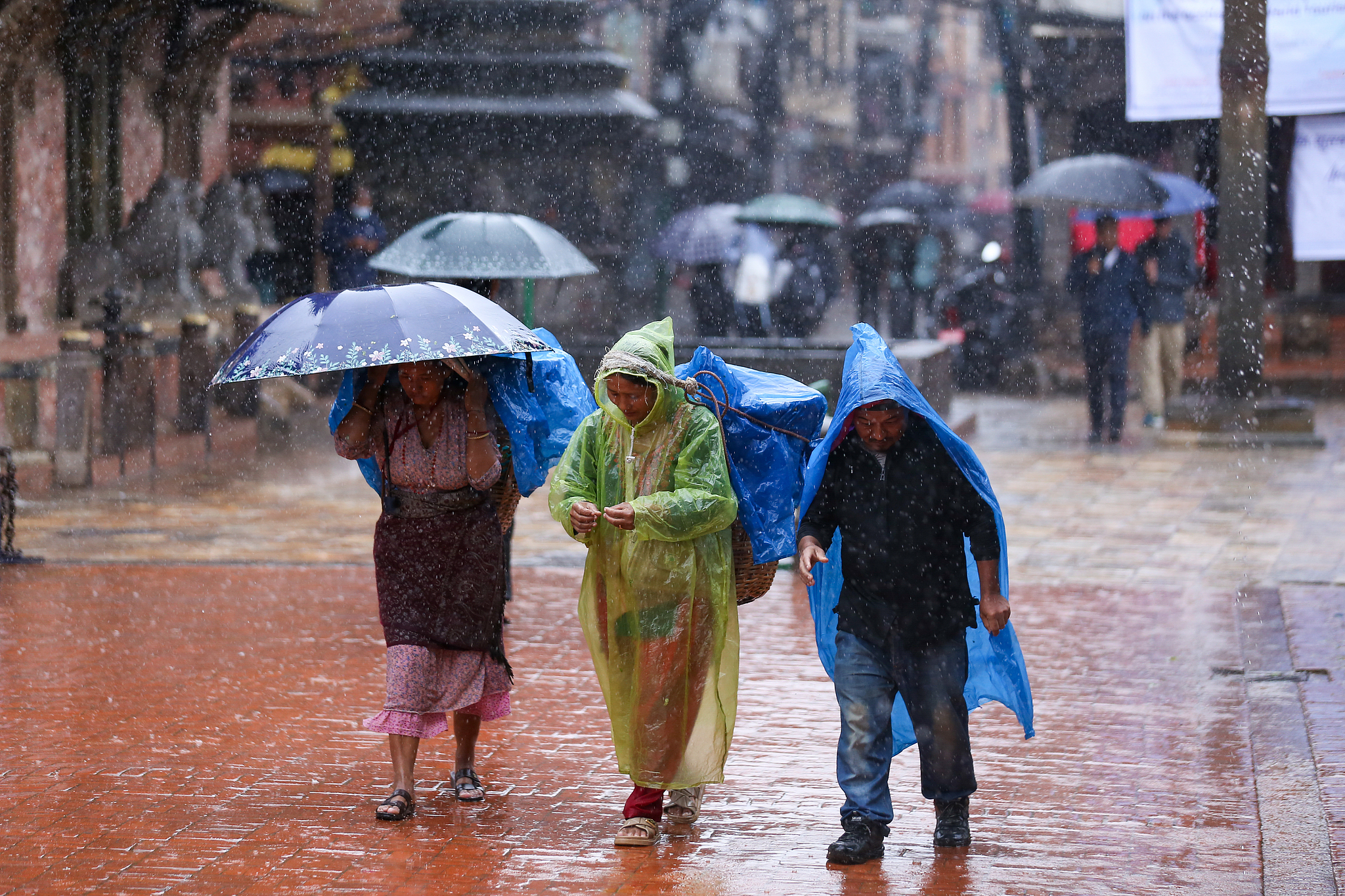 People with umbrellas walk around Patan Durbar Square, a UNESCO World Heritage Site in Lalitpur, Nepal, September 27, 2024. /CFP