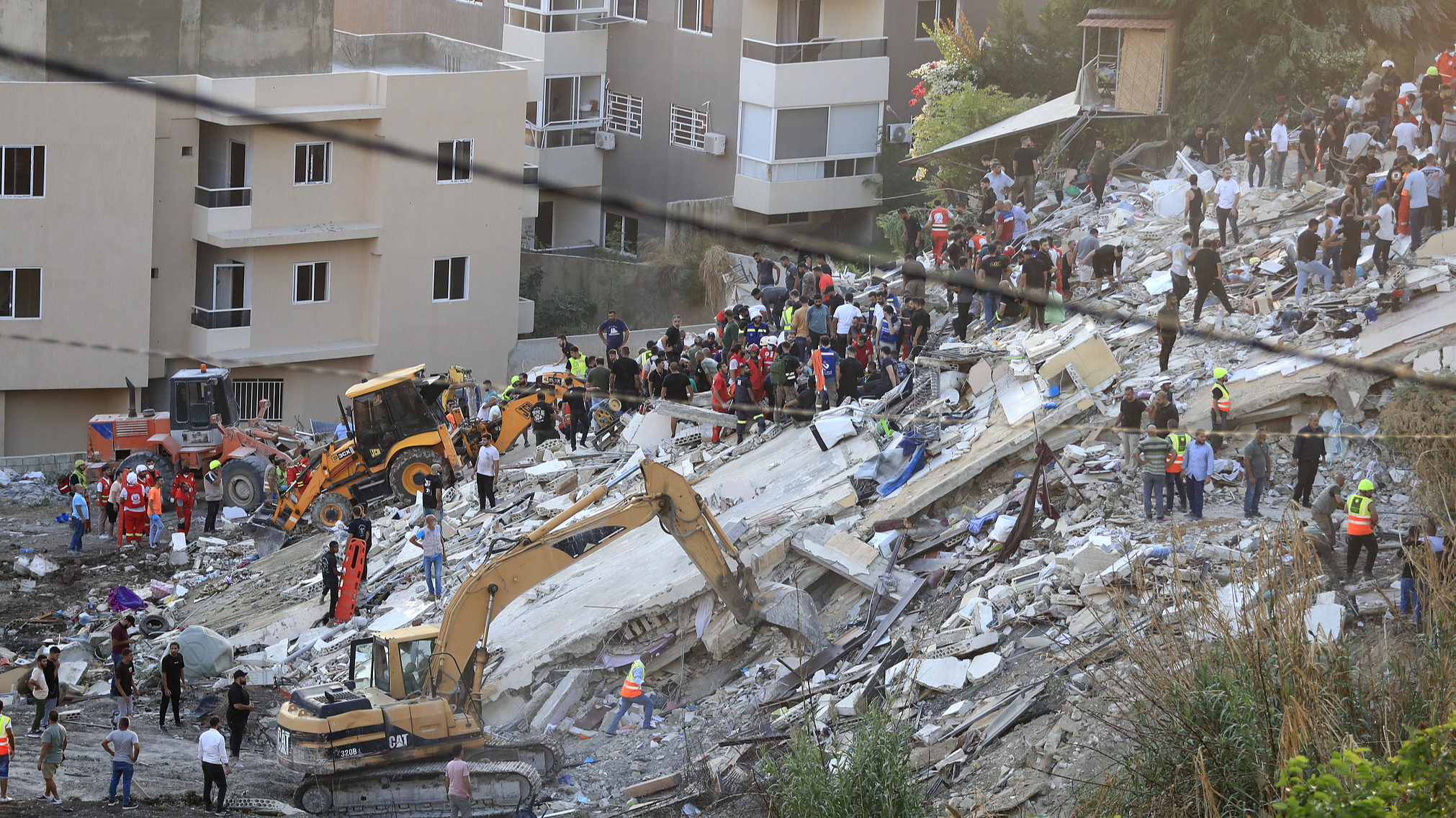 People and rescue teams search for victims after an Israeli air strike hit two adjacent buildings, in Ain el-Delb neighborhood east of the southern port city of Sidon, Lebanon, September 29, 2024. /CFP