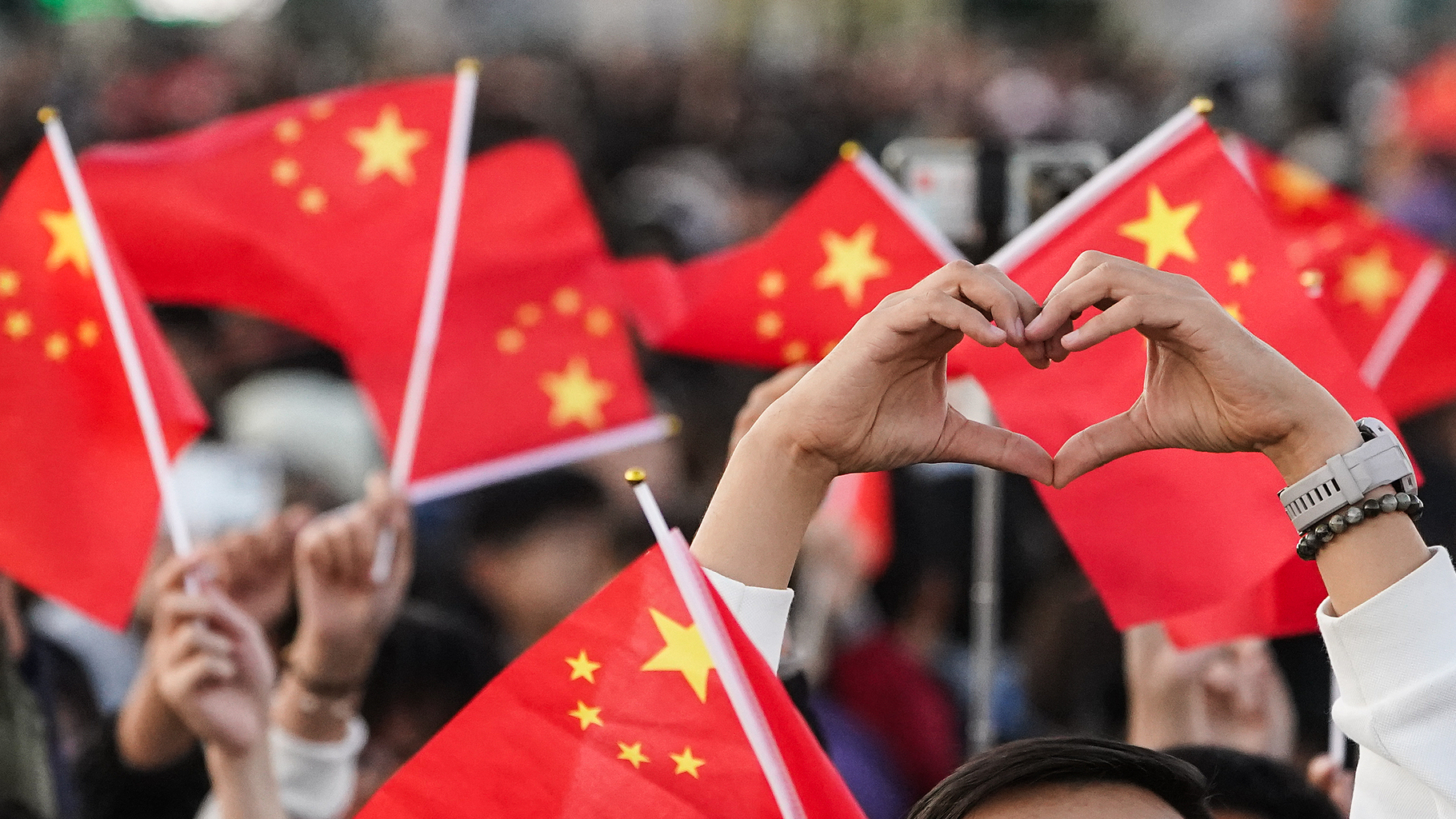 Tourists wave flags at Tiananmen Square in Beijing to celebrate National Day on October 1, 2024, the 75th anniversary of the founding of the People's Republic of China. /CFP