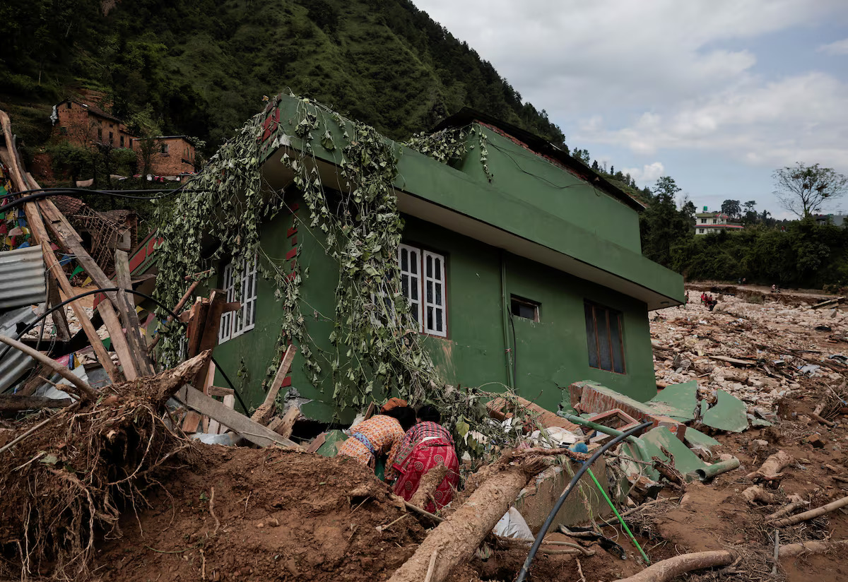 People retrieve goods from a damaged house swept by the deadly flood following heavy rainfall along the bank of Roshi River at Panauti in Kavre, Nepal September 30, 2024. /Reuters