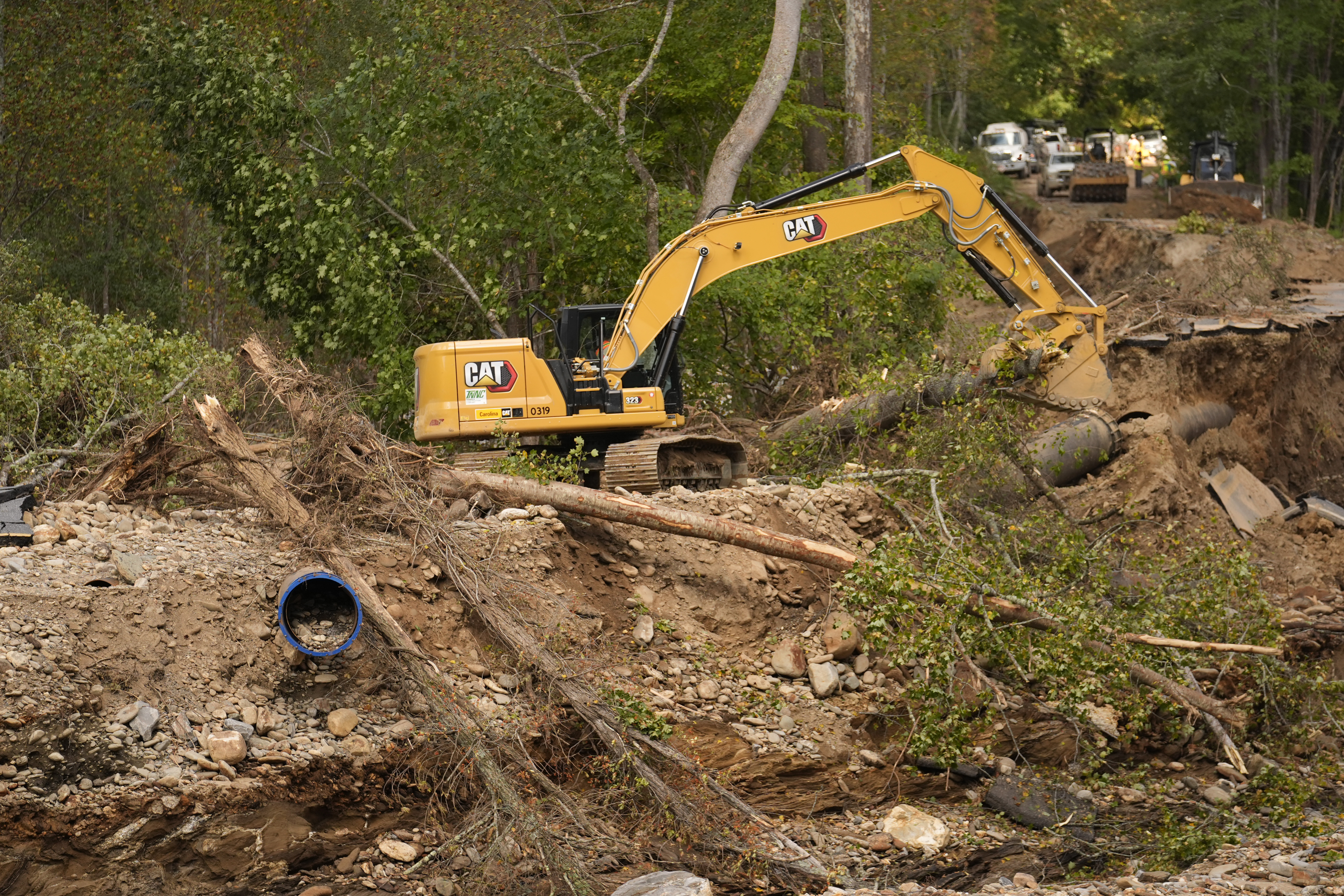 A backhoe is used to clear debris left by Hurricane Helene that washed away a road and destroyed a waterline for the city of Asheville, North Carolina, U.S., October 2, 2024. /AP