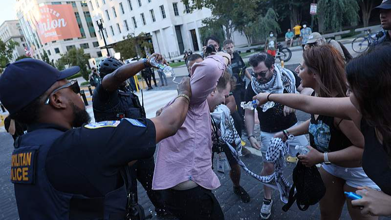 Police help a man who tried to set himself on fire as people demonstrate to mark one year of the war between Hamas and Israel in front of the White House in Washington, D.C., U.S., October 5, 2024. /CFP