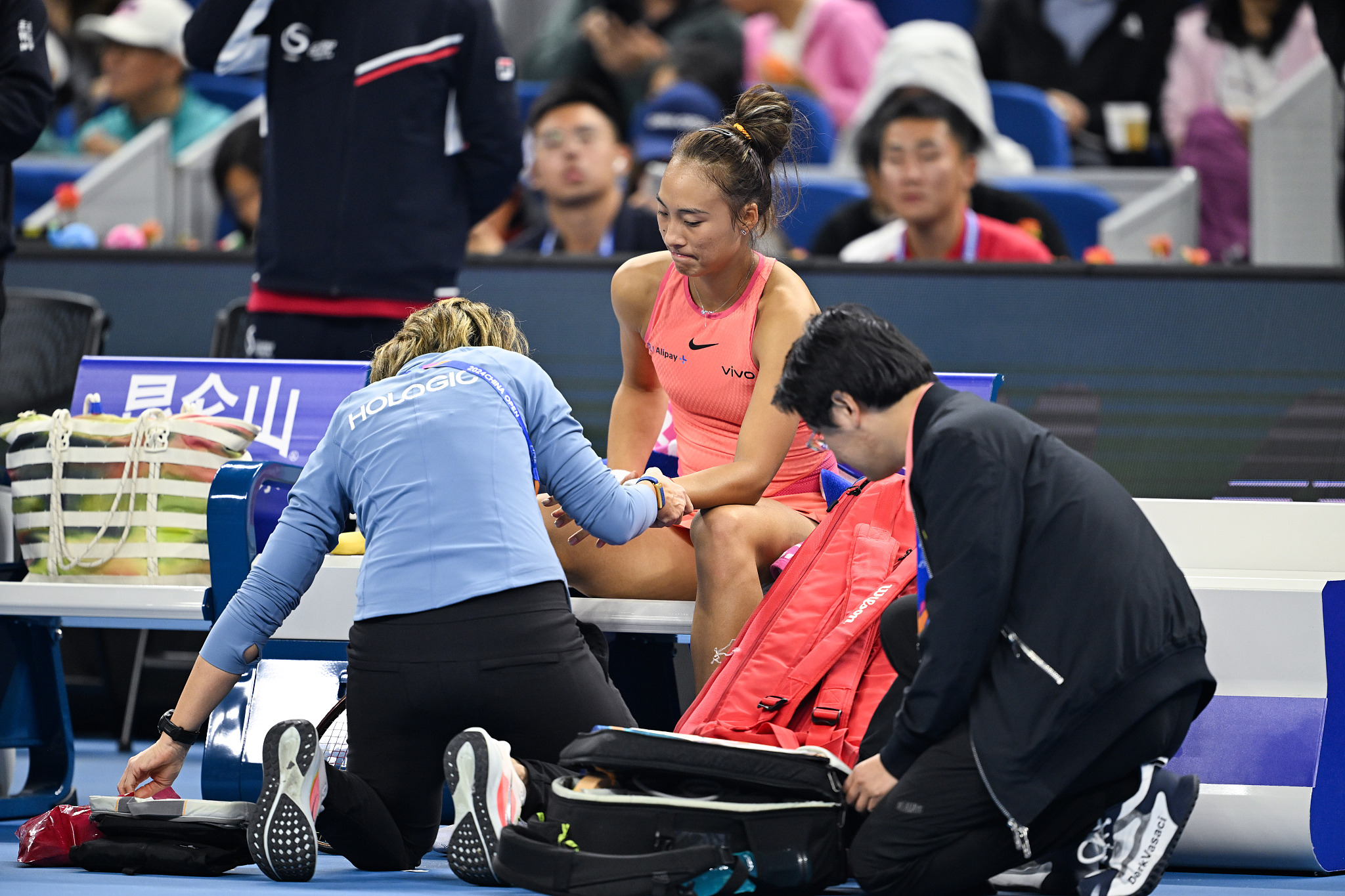 Zheng Qinwen (C) of China receives medial treatment during the women's singles semifinal at China Open in Beijing, China, October 5, 2024. /CFP