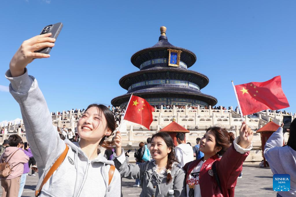 Tourists take selfies at Tiantan (Temple of Heaven) Park in Beijing, capital of China, October 1, 2024. /Xinhua