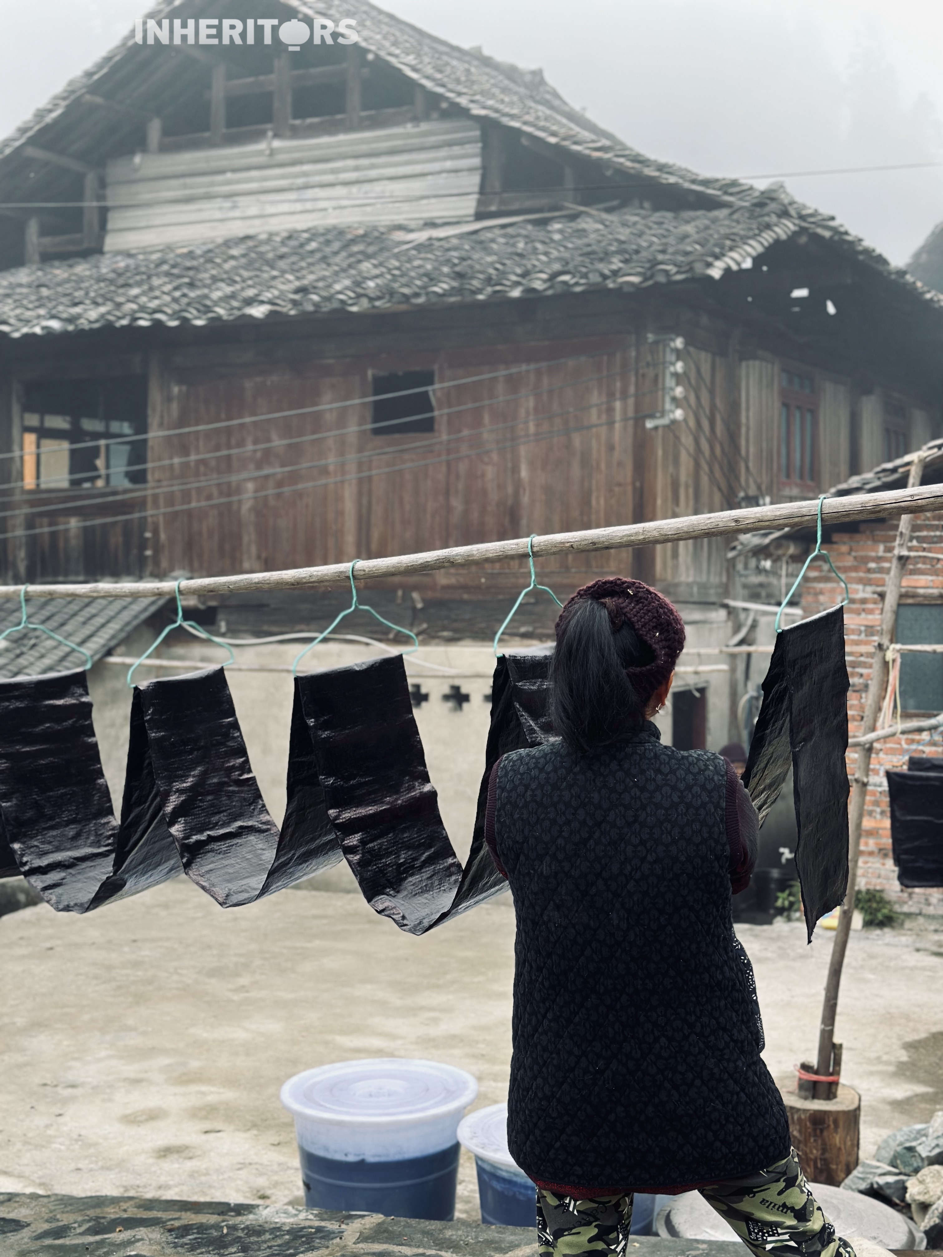 A woman dries a piece of cloth after dyeing at a Dong village in southwest China's Guizhou Province. /CGTN