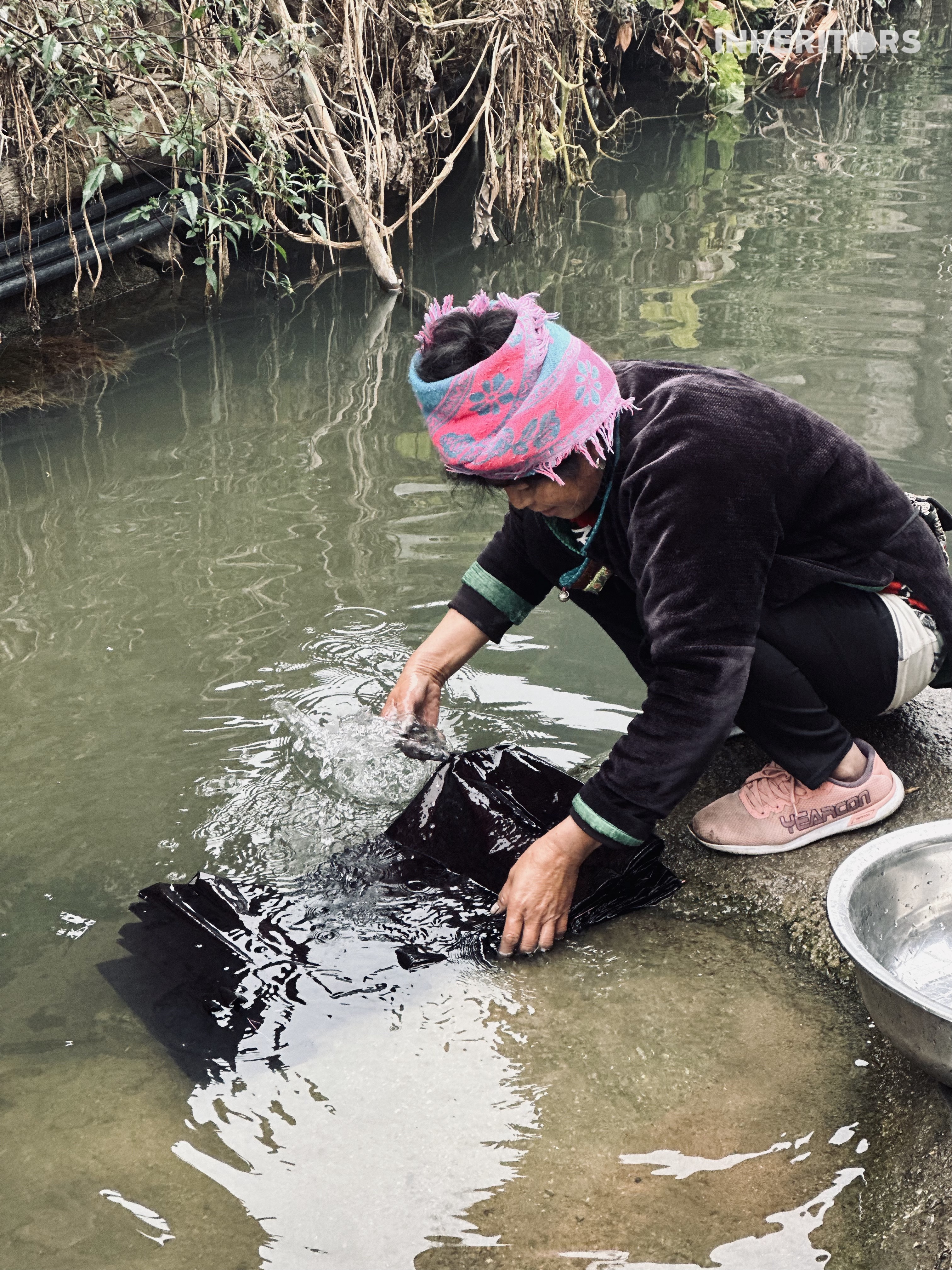 A woman washes a piece of cloth after dyeing at a Dong village in southwest China's Guizhou Province. /CGTN