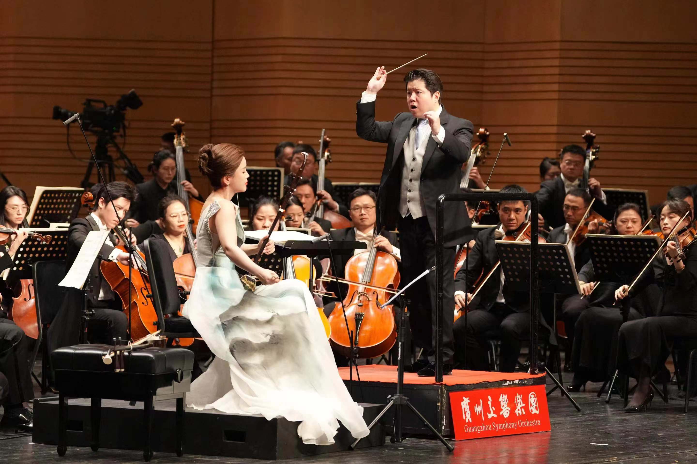 Huang Yi, music director of the Guangzhou Symphony Orchestra, conducts the concert described as a graceful encounter between Chinese tradition and Western myth. Lu Yiwen (dressed in white) was the erhu soloist for this performance in Beijing on October 8, 2024. /Photo provided to CGTN