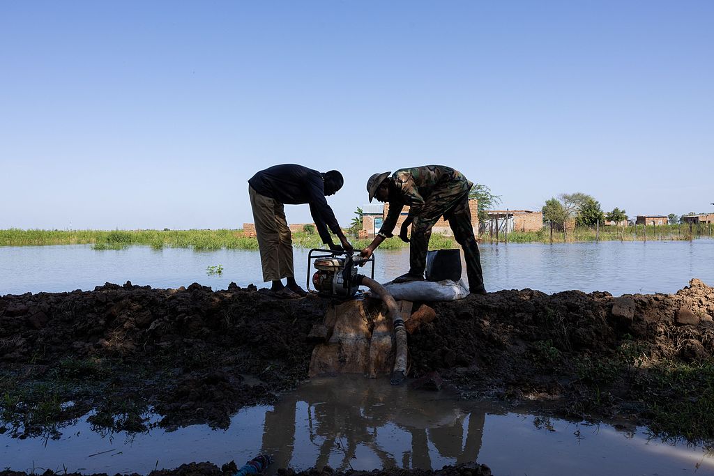 Two men start up a motor pump to clear floodwater in the Tougoude district, southeast of the ninth district of Chad's capital N'Djamena, October 8, 2024. /CFP