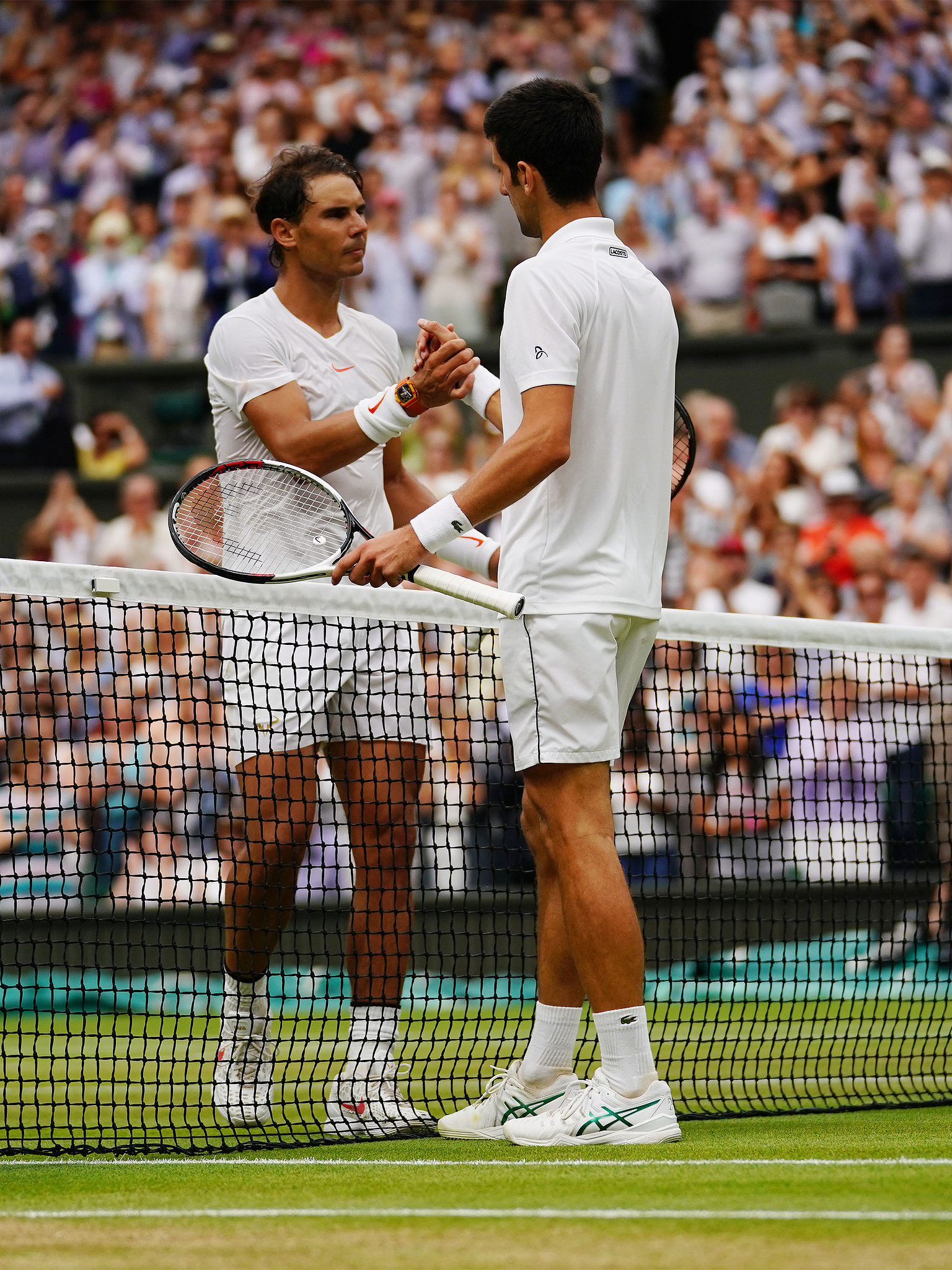 Novak Djokovic (R) and Rafael Nadal shake hands at the net during the Wimbledon Championships in London, England, July 14, 2018. /CFP 