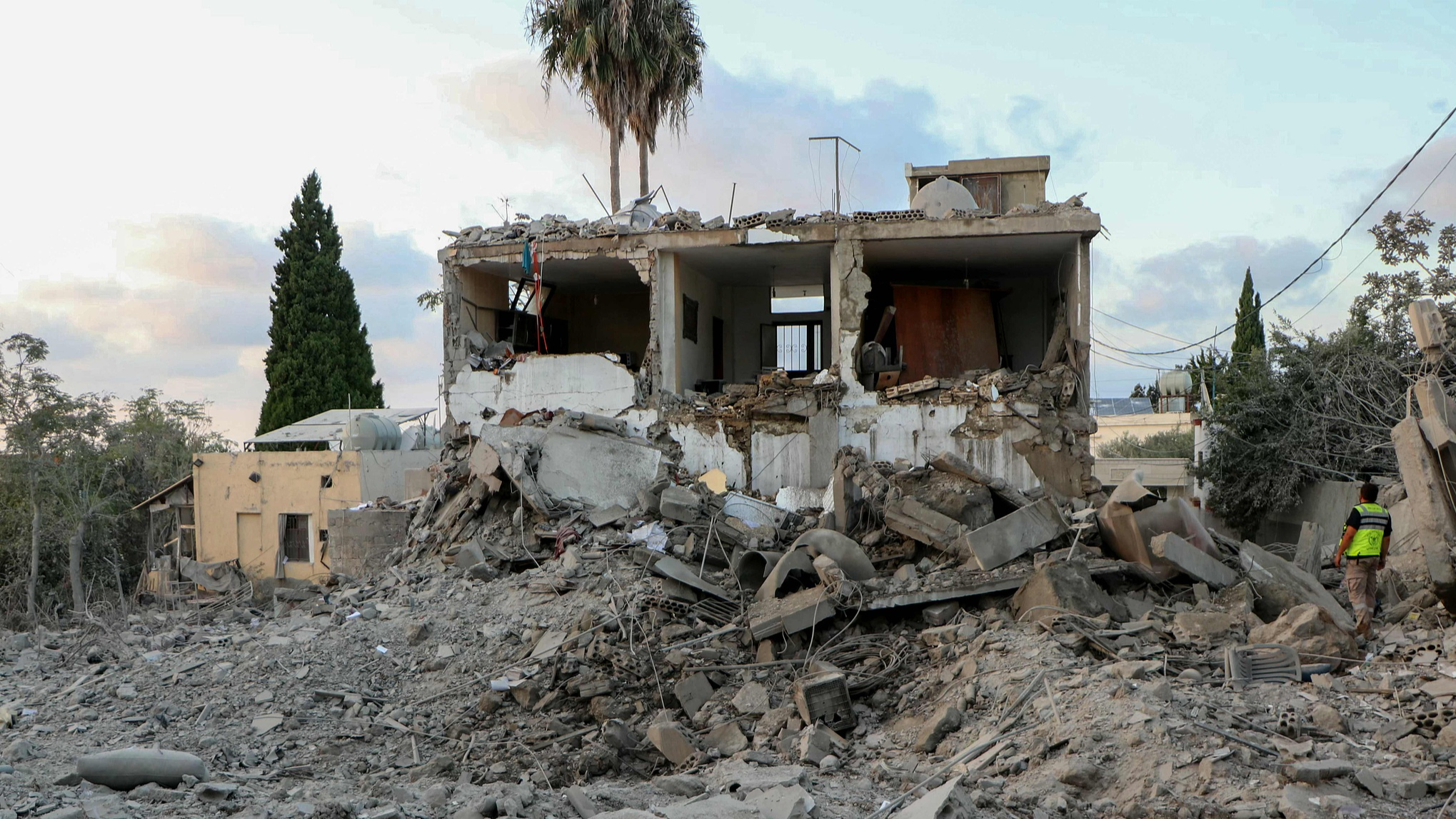 A rescuer stands on the rubble of a building destroyed in an Israeli airstrike that targeted the southern Lebanese village of Hanouiyeh, Lebanon, October 13, 2024. /CFP